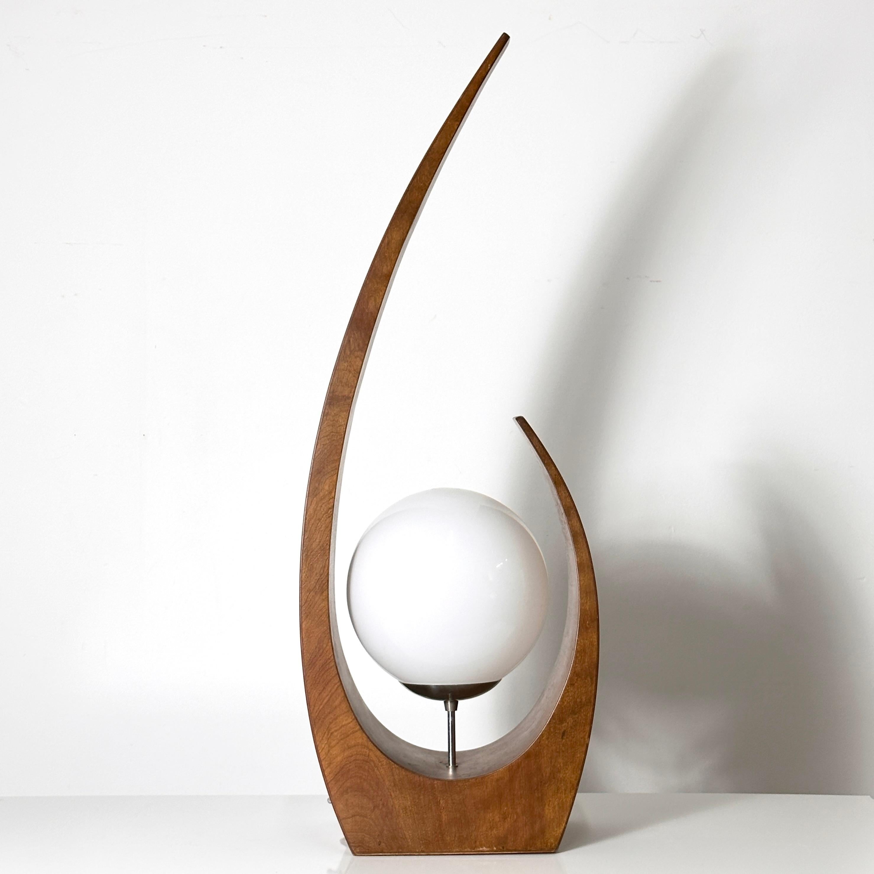 Rare Mid Century Modern table lamp designed by Jack Haywood for Modeline of California circa 1970s.
Sculptural walnut plywood base with center floating white glass globe shade.