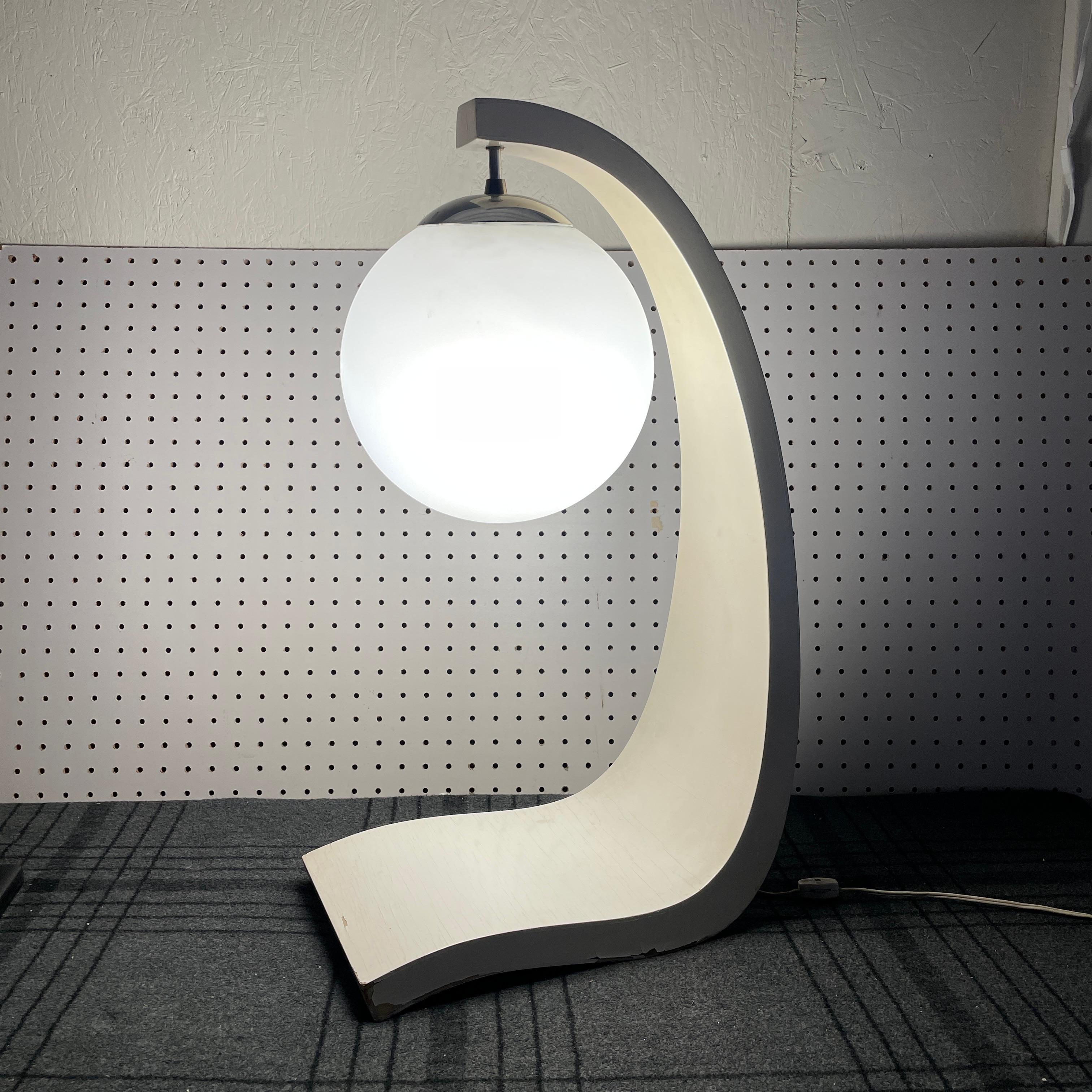 A rare mid-century modern table lamp designed by architect Jack Haywood for Modeline of California. Features a curving wooden frame and a frosted glass shade. Lamp works perfectly and looks incredible lit up. It has a felt pad on the bottom to keep