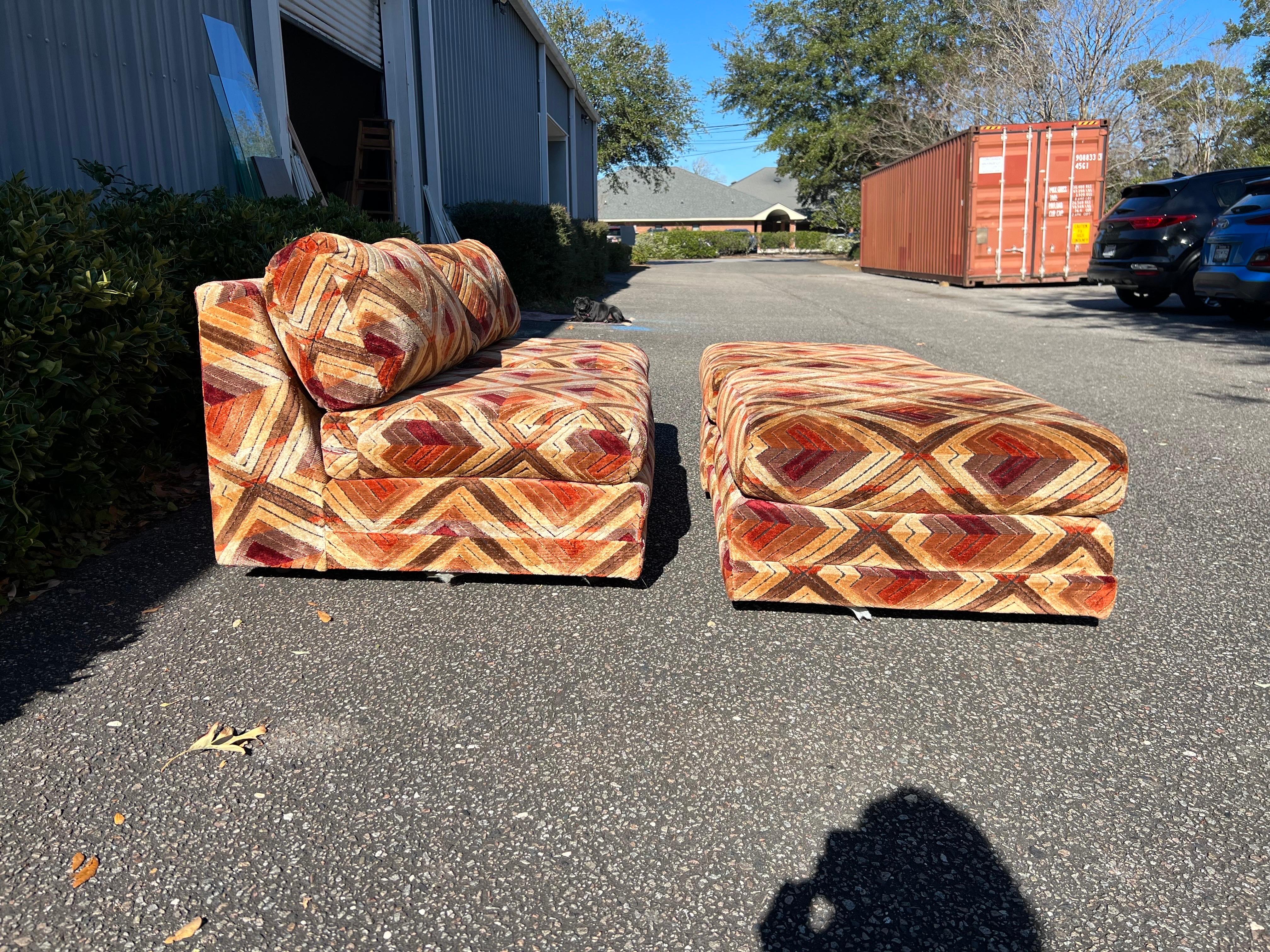 Awesome mod armless loveseat length sofa with 2 matching ottomans upholstered in Jack Lenor Larsen style geometric fabric in shades of brown, rust, and tan. It is in wonderful vintage condition and has been professionally cleaned. Please see photos,