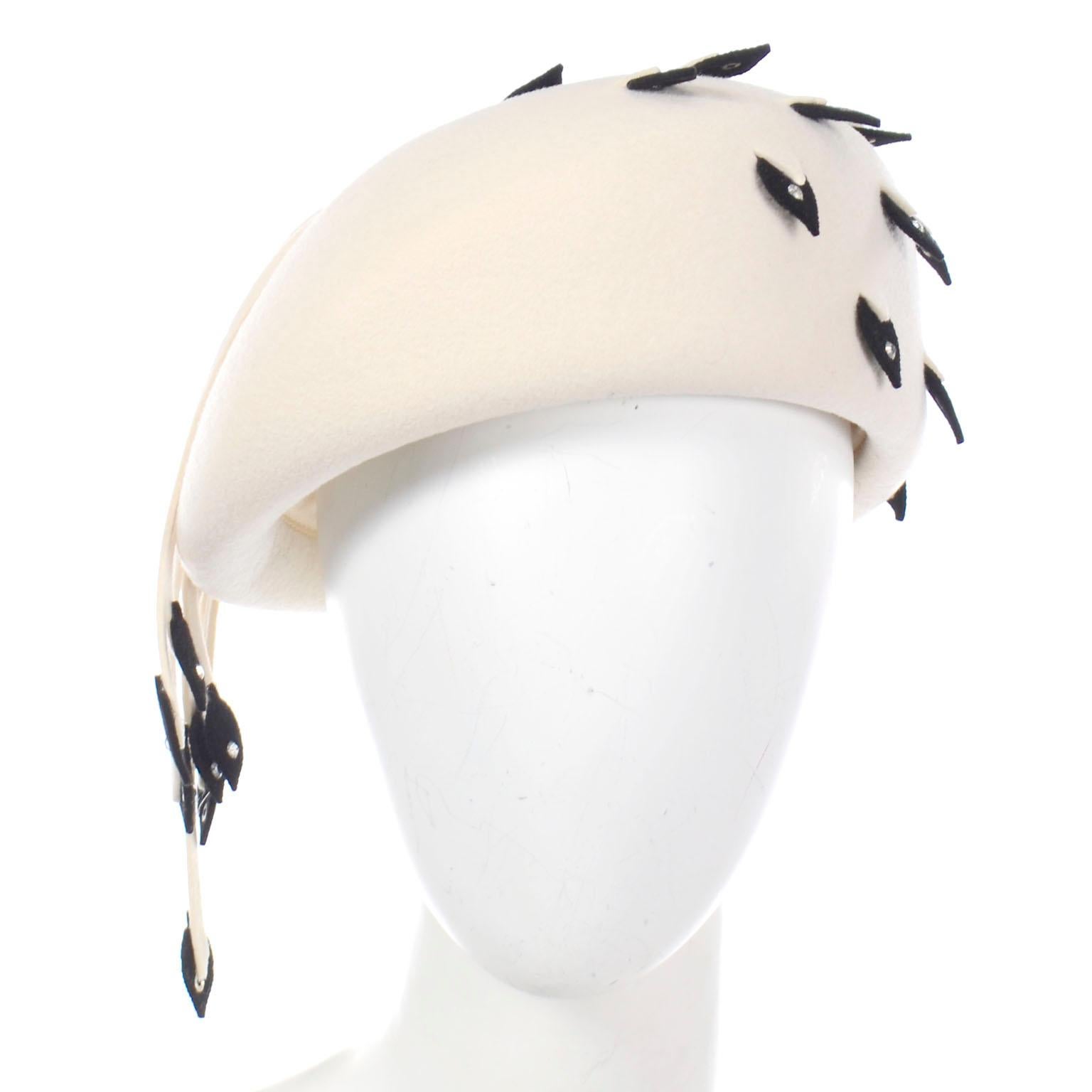 We love vintage Jack McConnell hats and this unique vintage beret is such a fun hat to add to your collection! This beautiful fascinator winter white / ivory wool beret style hat has unique black leaf shaped appliques with rhinestones and strips of