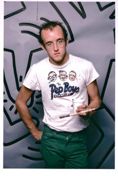 Graffiti artist Keith Haring photographed with his work