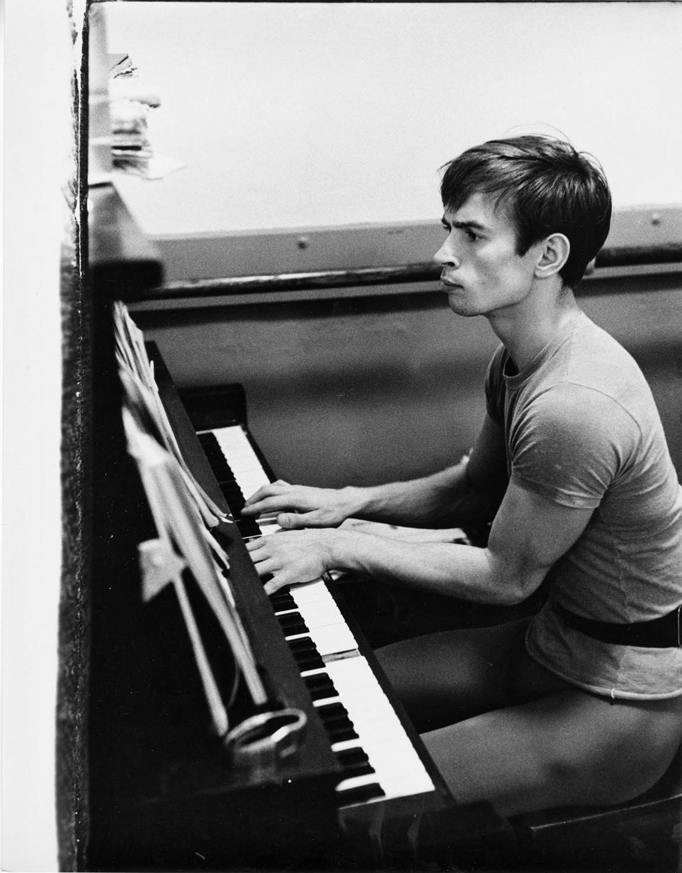 Jack Mitchell Black and White Photograph - Rudolf Nureyev photographed playing the piano during a rehearsal break