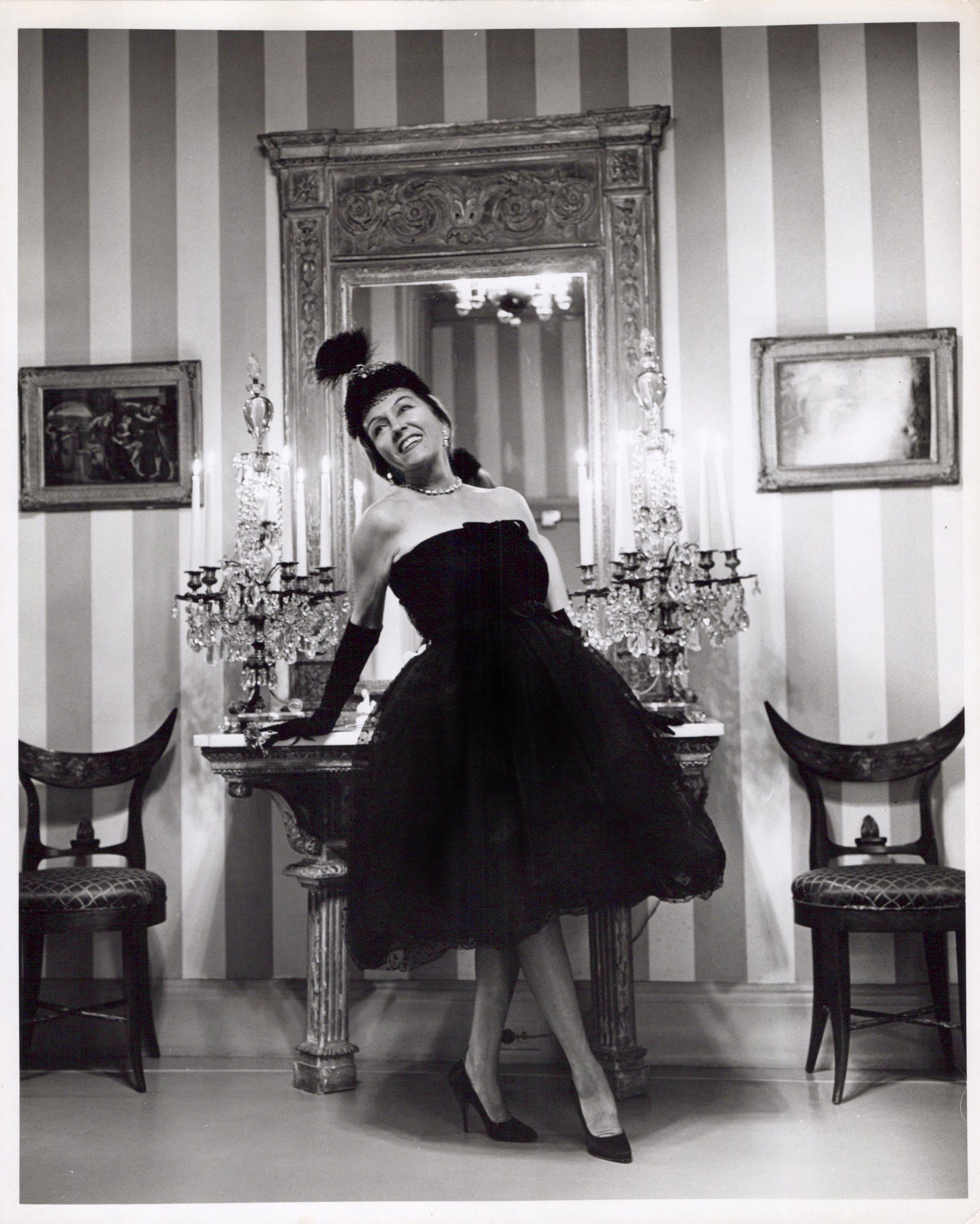 Black and White Photograph de Jack Mitchell - La estrella del cine y la televisión Gloria Swanson posando en el vestíbulo de su casa de Nueva York