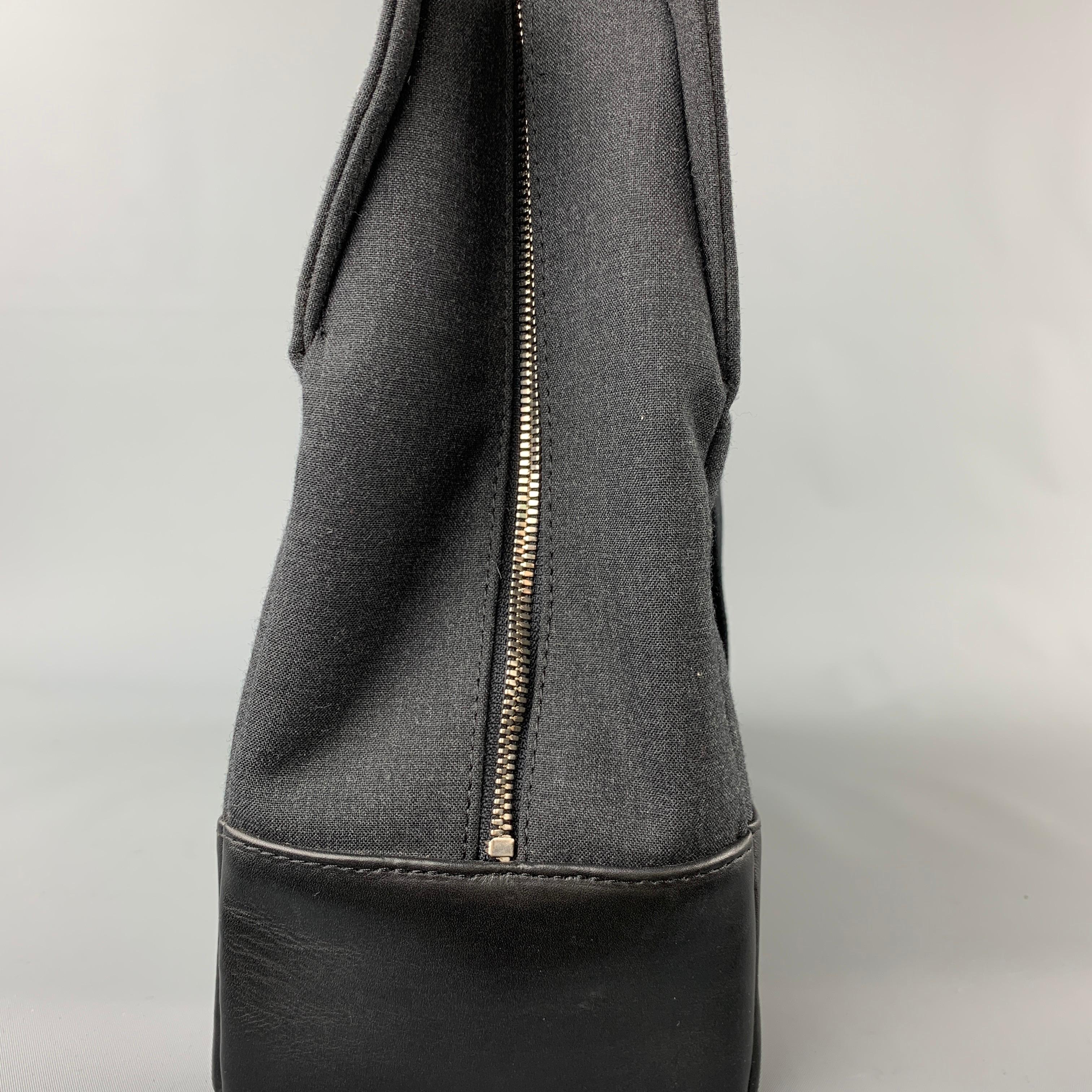 JACK SADE laptop bag comes in a charcoal canvas with a black leather trim featuring a shoulder strap, top handles, inner slots, silver tone hardware, and a zip up closure. 

Very Good Pre-Owned Condition.

Measurements:

Length: 15.5 in.
Width: 5