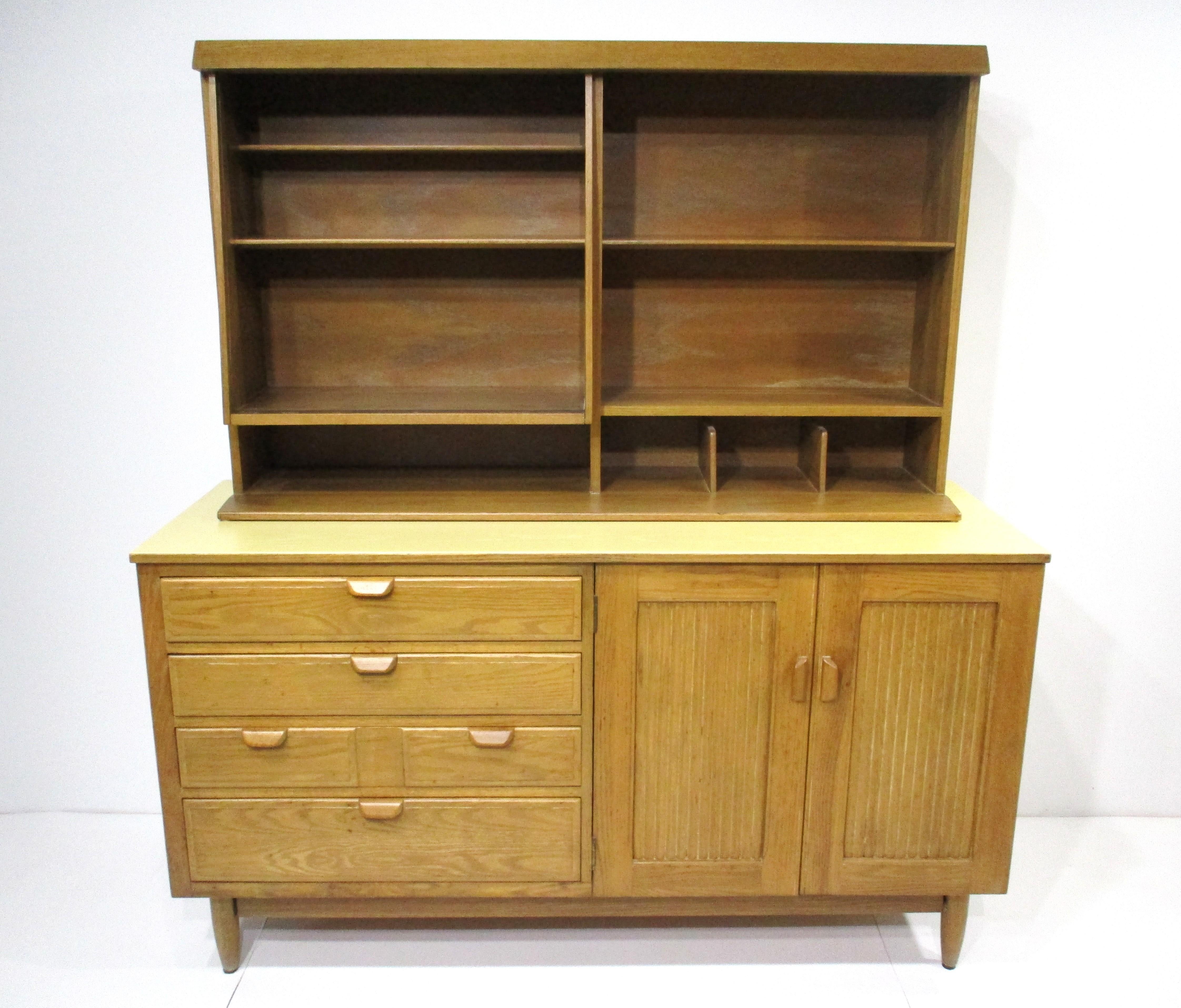 A very functional 2 piece cabinet / sever with upper fixed shelved display area or bookcase with angled aesthetic design . The lower cabinet has four drawers , two doors and a fixed shelve giving you plenty of storage . This well crafted piece is