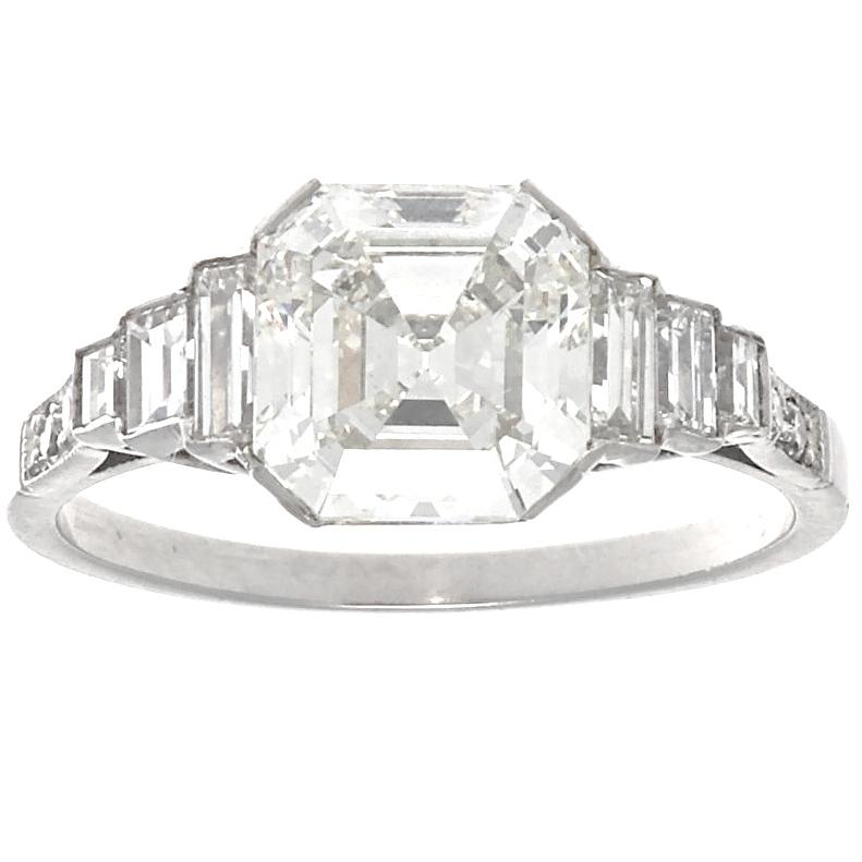 The perfect engagement ring features a clean and white emerald cut diamond with 6 baguette cut diamonds tapering down the shoulders. This Jack Weir & Sons 2.03 carat diamond ring features a K color,  VS2 clarity square emerald cut diamond that is as