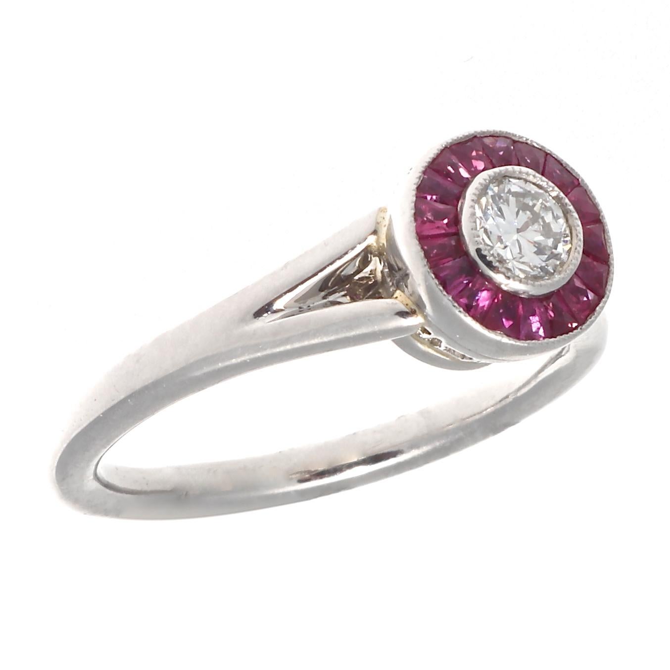 The halo diamond ring with bright red rubies. Featuring a lovely round brilliant cut diamond that has been surrounded by lively natural red rubies. Crafted in platinum. Ring size 5 and can easily be resized if needed, this would come complimentary