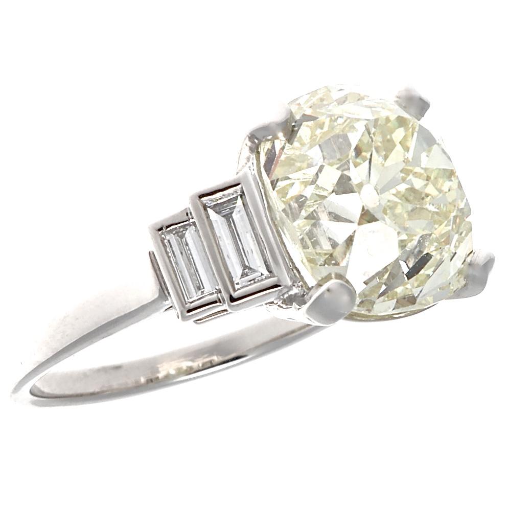 A modern ring made in the Art Deco style, featuring a 5.83 carat old mine cut diamond, O-P color VS clarity. Accented by four baguette diamonds  that weigh 0.30 carats total, G-H color VS1-VS2 clarity. This knockout is set in platinum, size 5 3/4,