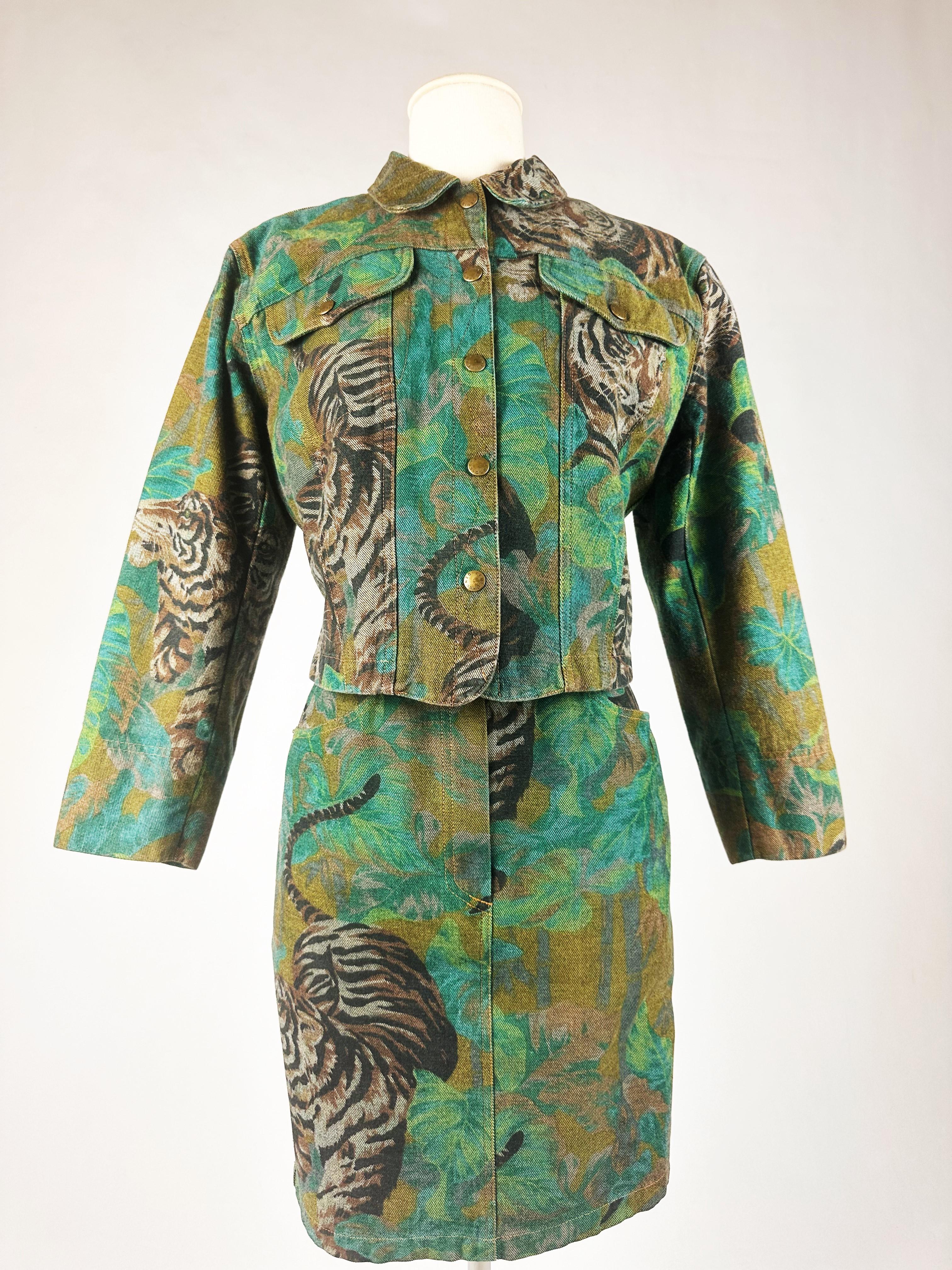 Circa 1990
France
Iconic denim jacket and skirt printed with Kenzo Takada's famous jungle and tiger motif, dating from the 1990s. Slim-fit jacket with double topstitching, back placket and two front flap pockets. Closes with five gold brass press