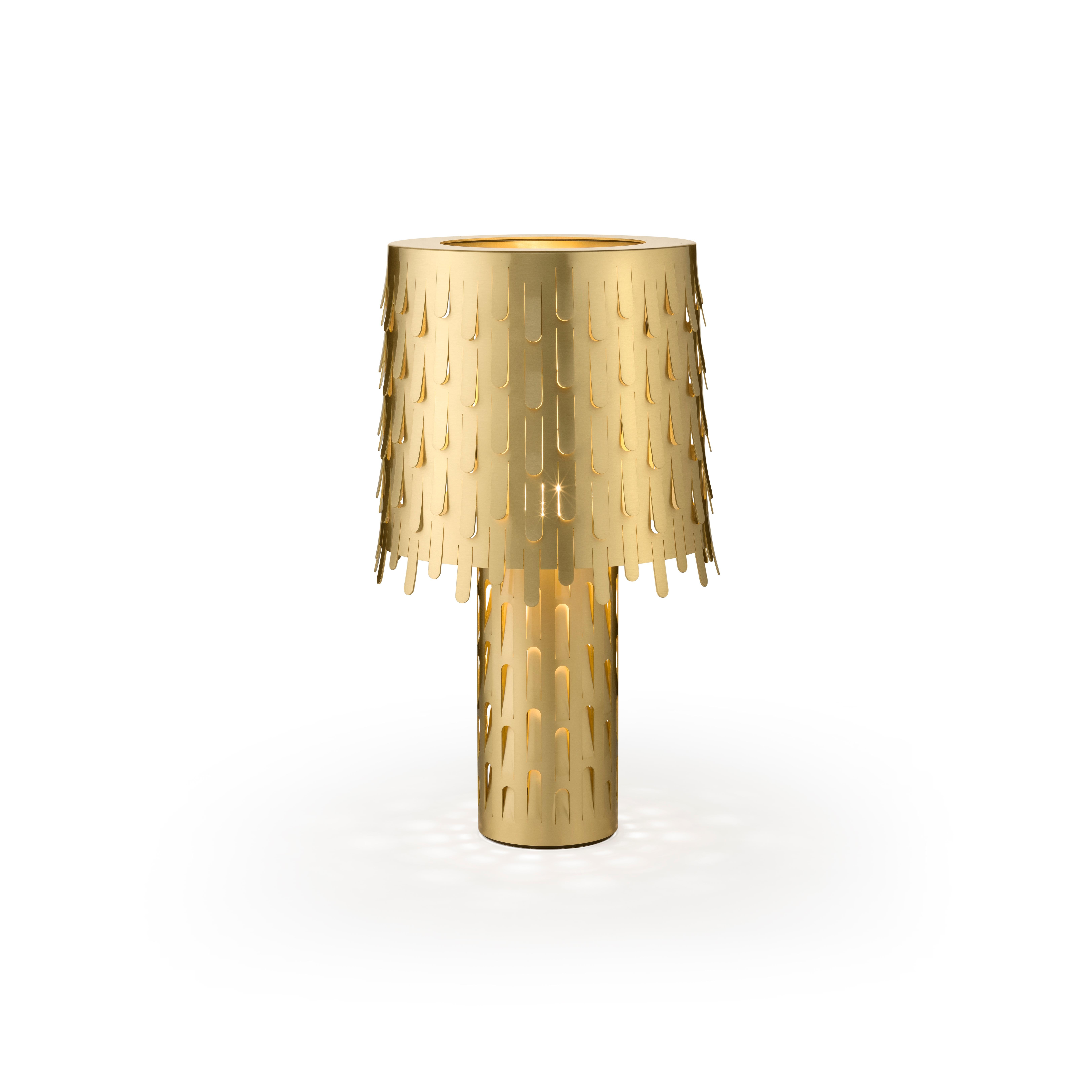 Jackfruit table lamp by campana brothers. The lamp is made of polished brass, synonymous of elegance and preciousness. It is composed of two overlapping cylinders, the large stem supports an important lampshade decorated with a thousand leaves bent
