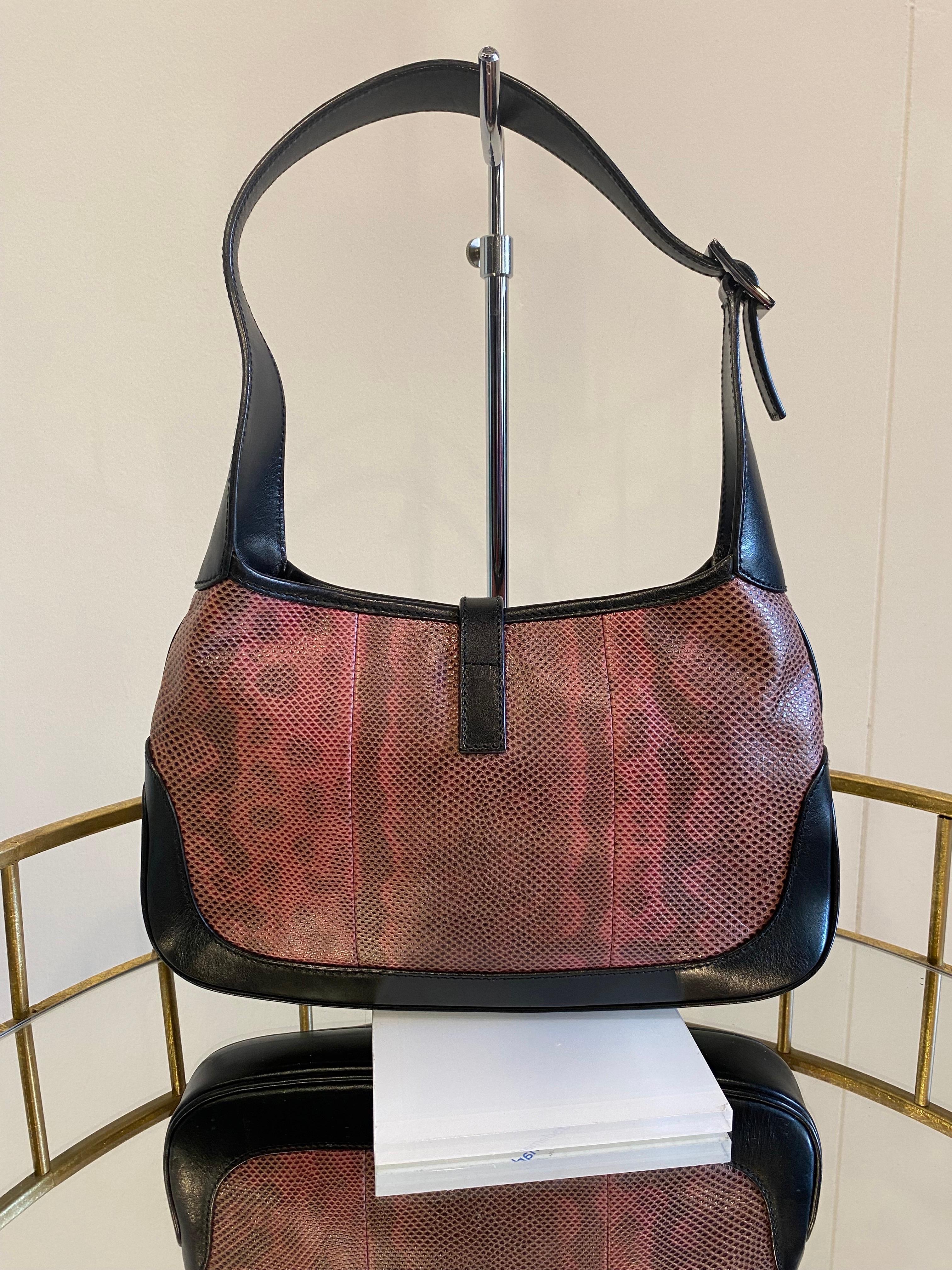 Jackie bag in pink lizard and black leather. Black fabric interior with a small zip pocket. Closure with silver hardware. Well preserved item, shows very small signs of normal use.
Item salable only in the European Union.
Width 26 cm
Height