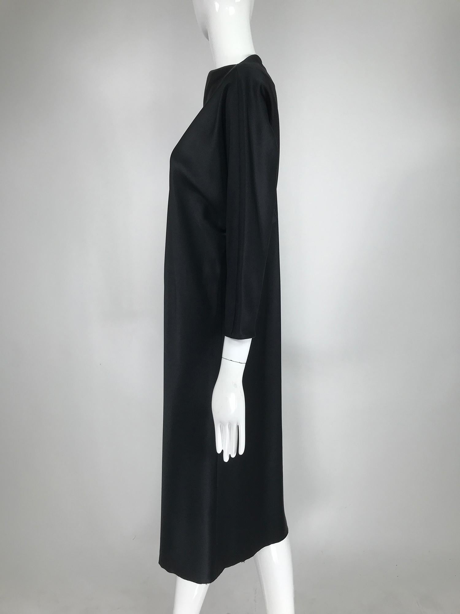 Jackie Rogers classic silky black satin bias cut dress from the 1990s. The perfect black dress to dress up with jewelry and or a belt. The dress slips over the head, the bias cut does the rest. Picot hem. Unlined the fabric is light with a beautiful