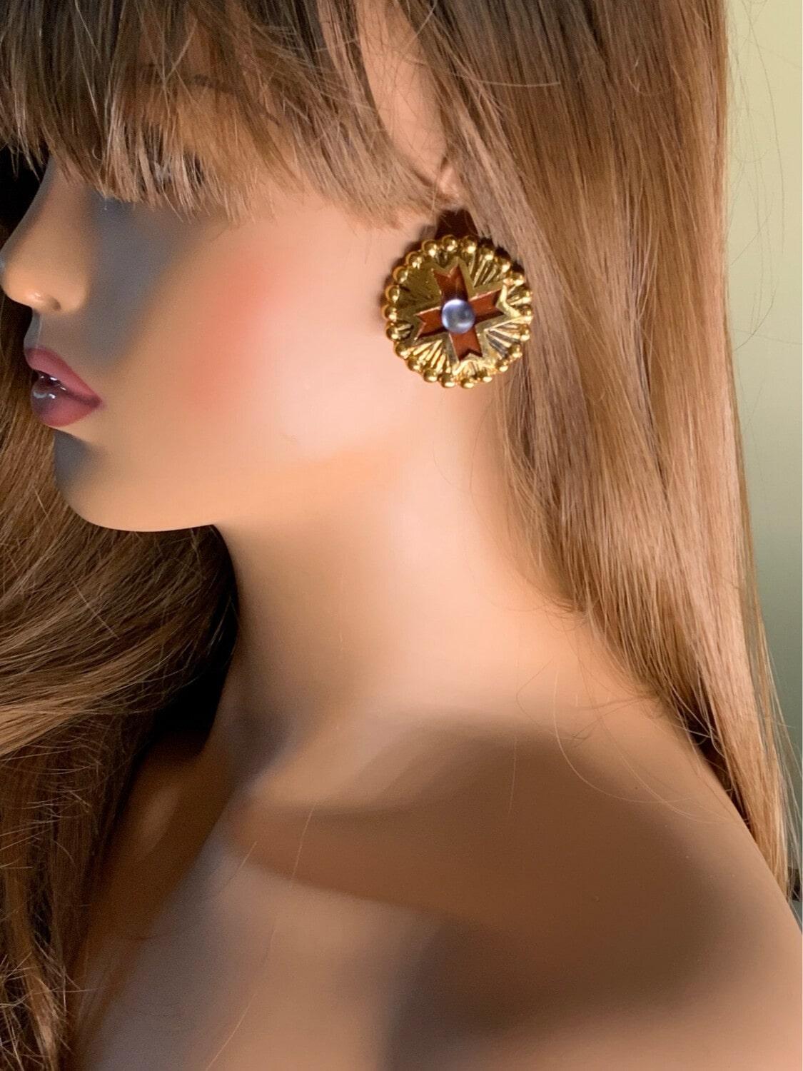 Jacky de G's style is extremely recognizable and very consistent. We find once again his paw in this pair of earrings, they are in the very effective style. Clasp with clips, gold metal, dominant stone in resin and chocolate color.

I am a partner