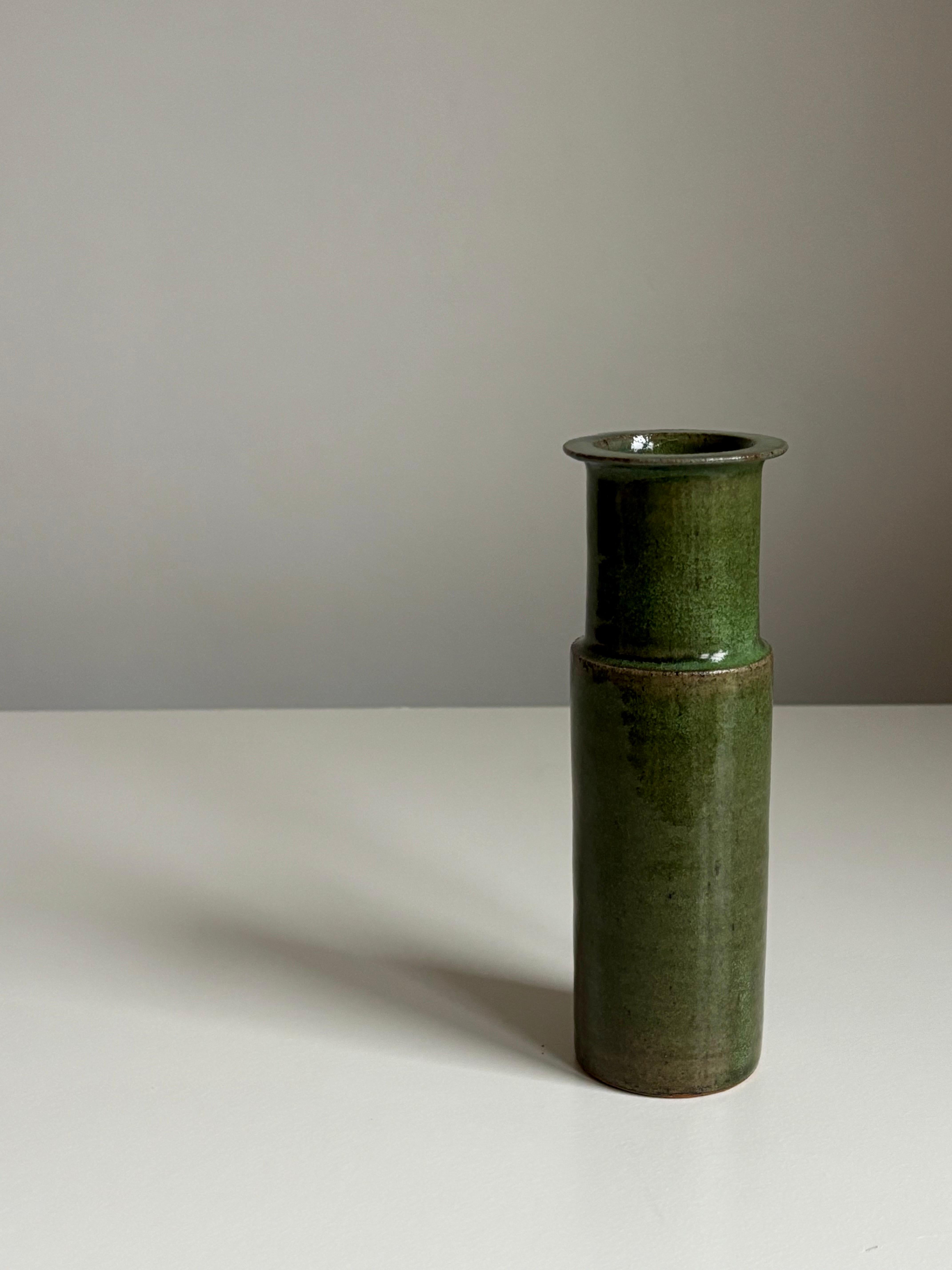Slender midcentury modern ceramic vase with stunning olive green glaze. Simple smooth shape with sharp edges. 
Handmade in the 1960s by ceramic artist Jacob Bang (1932-2011), son of Arne Bang. 
Signed and numbered with the Jacob and Arne Bang