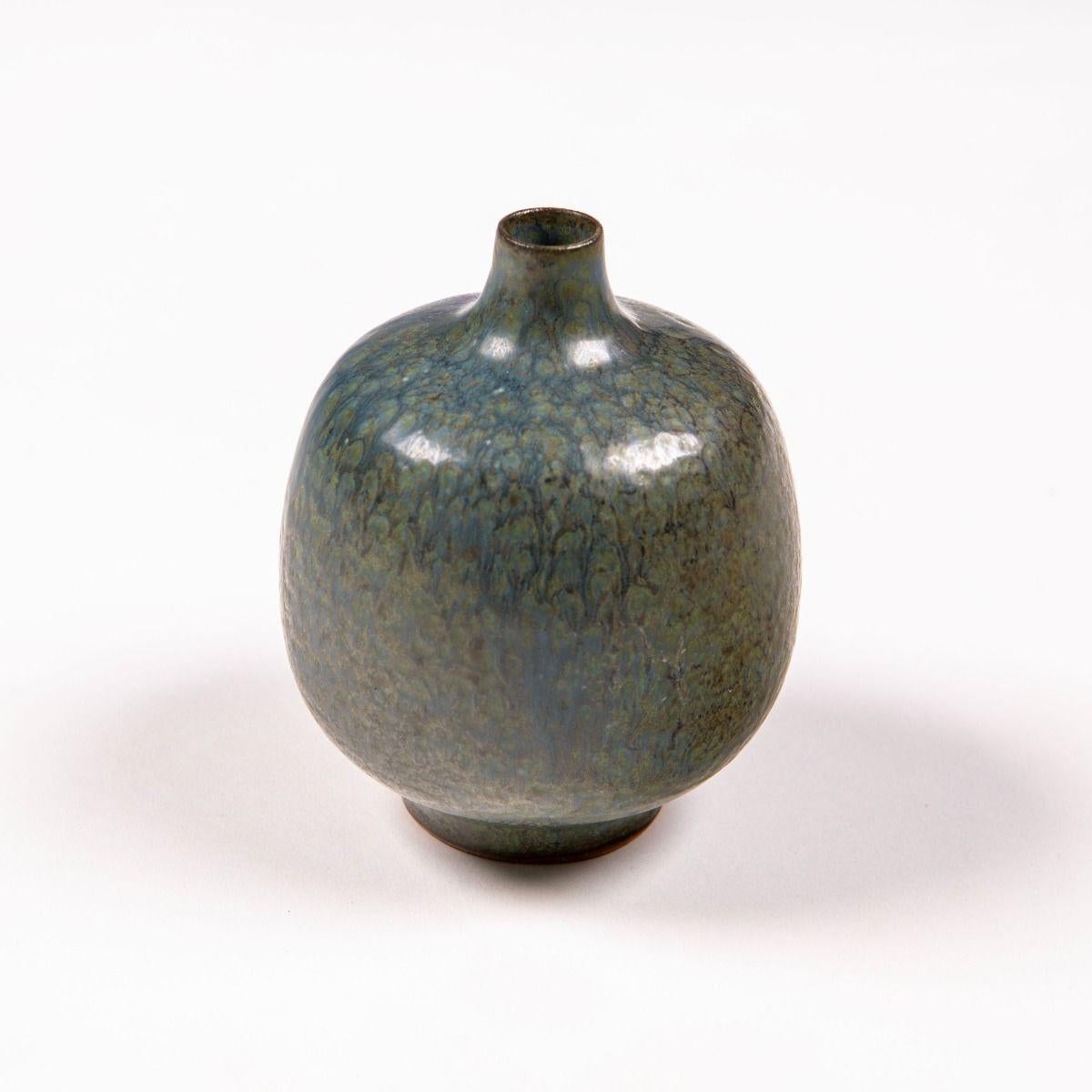 Élégant petit vase créé par le céramiste danois Jacob Bang (1932-2011), figure notable du design scandinave du XXe siècle.
Le vase présente un corps joliment arrondi qui se transforme en un col élancé avec une bouche étroite. Il est recouvert d'une