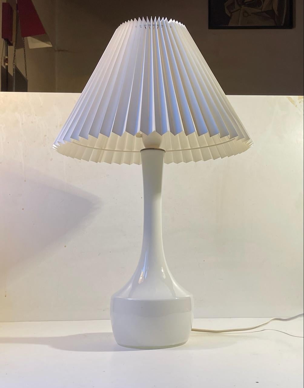 A rare organically shaped long neck table light in cased white opaline glass. Designed by the kid-brother of Arne Bang alias Jacob Eiler Bang in the mid to late 1950s. Manufactured by Holmegaard/Kastrup in Denmark. Fluted white new Danish shade is