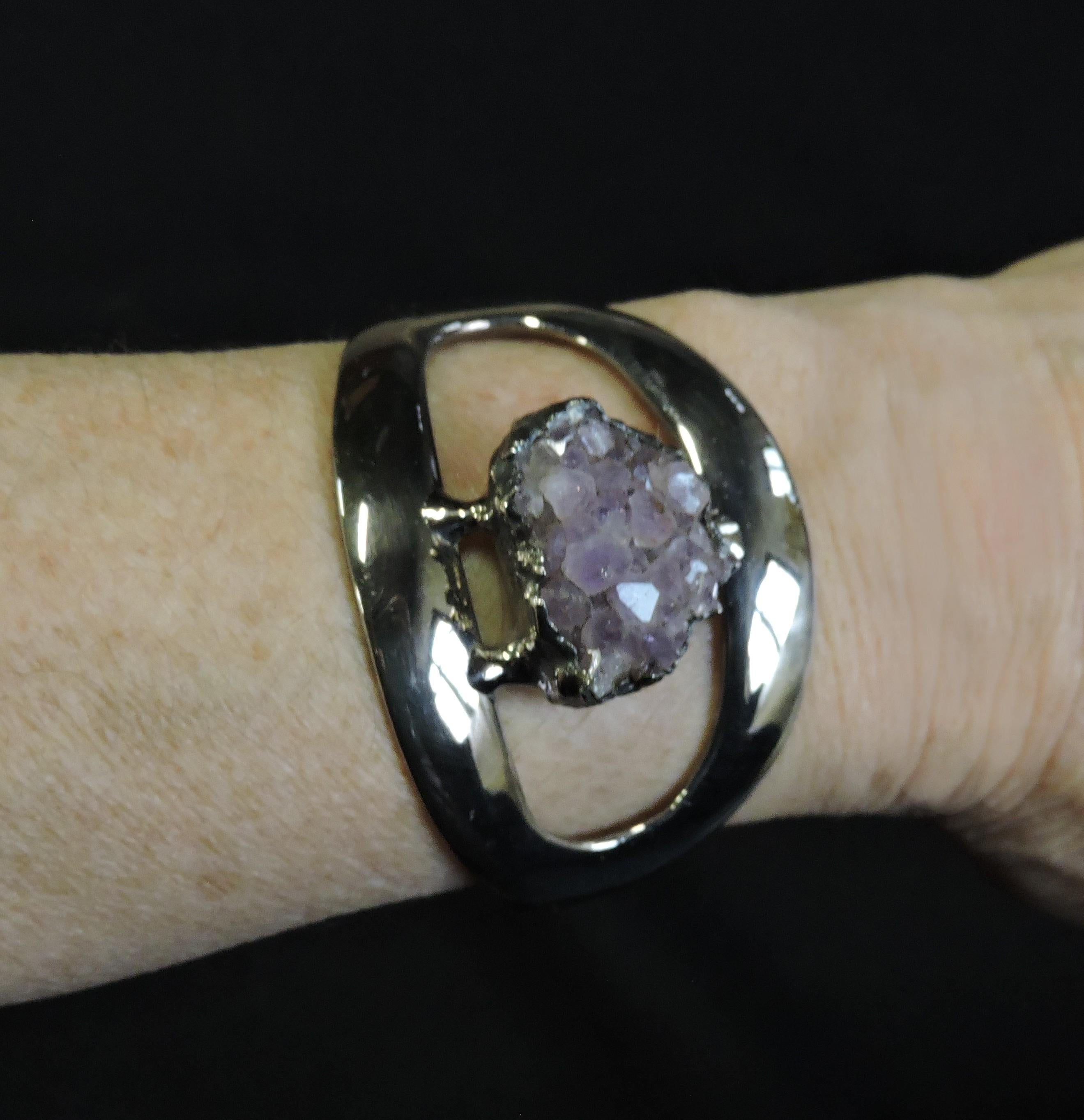 Striking sculptural brutalist style cuff bracelet by acclaimed Danish artist, Jacob Hull. This piece is silver plated with a raw amethyst in the center. It measures about 2.25 inches from side to side, and is adjustable. Marked Jacob Hull, Denmark,