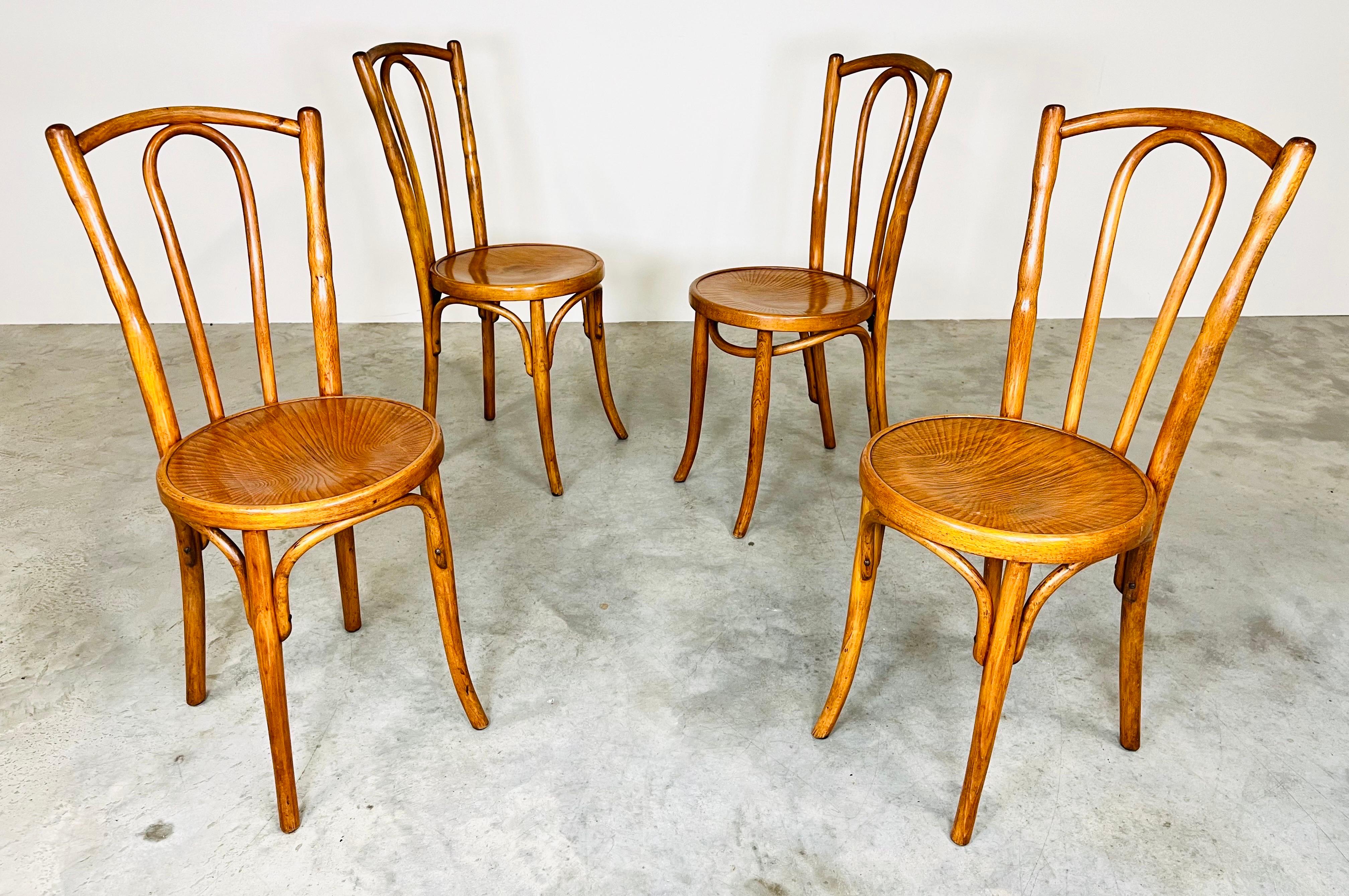Set of 4 Grotto style bentwood chairs marked with Mazowia as the maker. Chairs feature bentwood back with beautiful curved wood.
Seats each feature a beautiful unique grain pattern. 
Condition is consistent with age having gorgeous patina with
