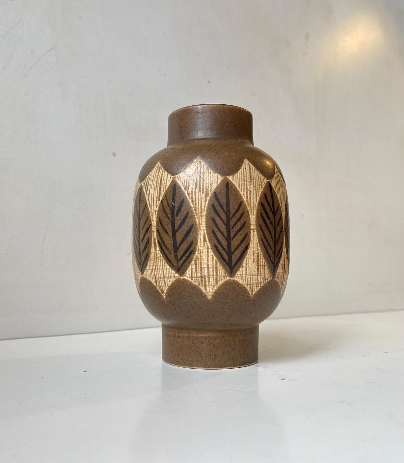 Jacob Siv for Syco, Strömstad, Swedish ceramist. Diablo shaped ceramic vase with glazes in brown shades and hand-painted leaf decor. Measures: 17 cm in height and has a diameter of 11 cm. Stamped and with label to its side. In perfect condition.