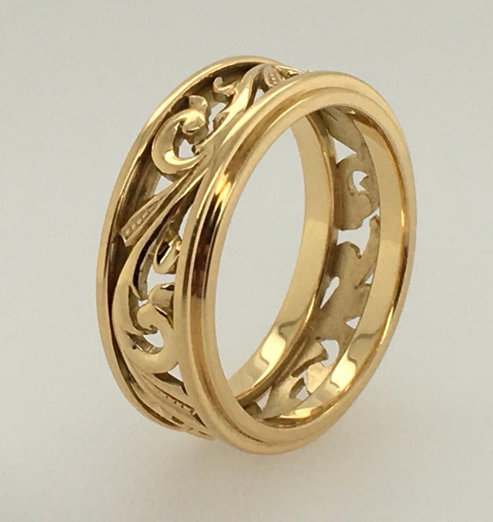 Cet étonnant anneau en or jaune 18 carats à volutes ouvertes est une bague de mariage originale profondément sculptée à la main par le bijoutier du Maine Jacob Snow.  Les détails complexes sont hautement polis, tout comme les bords en deux étapes,