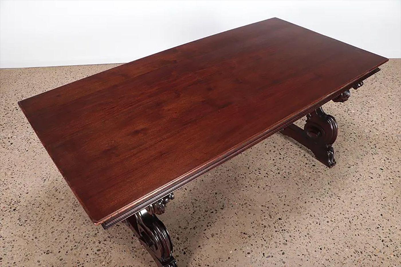 A Carved Jacobean Mahogany Dining, Center or Trestle Table having crossed iron stretchers circa 1920s. Solid Mahogany. Part of our extensive collection of over forty dining tables and chair sets as seen on this site, thus why we are referred to as