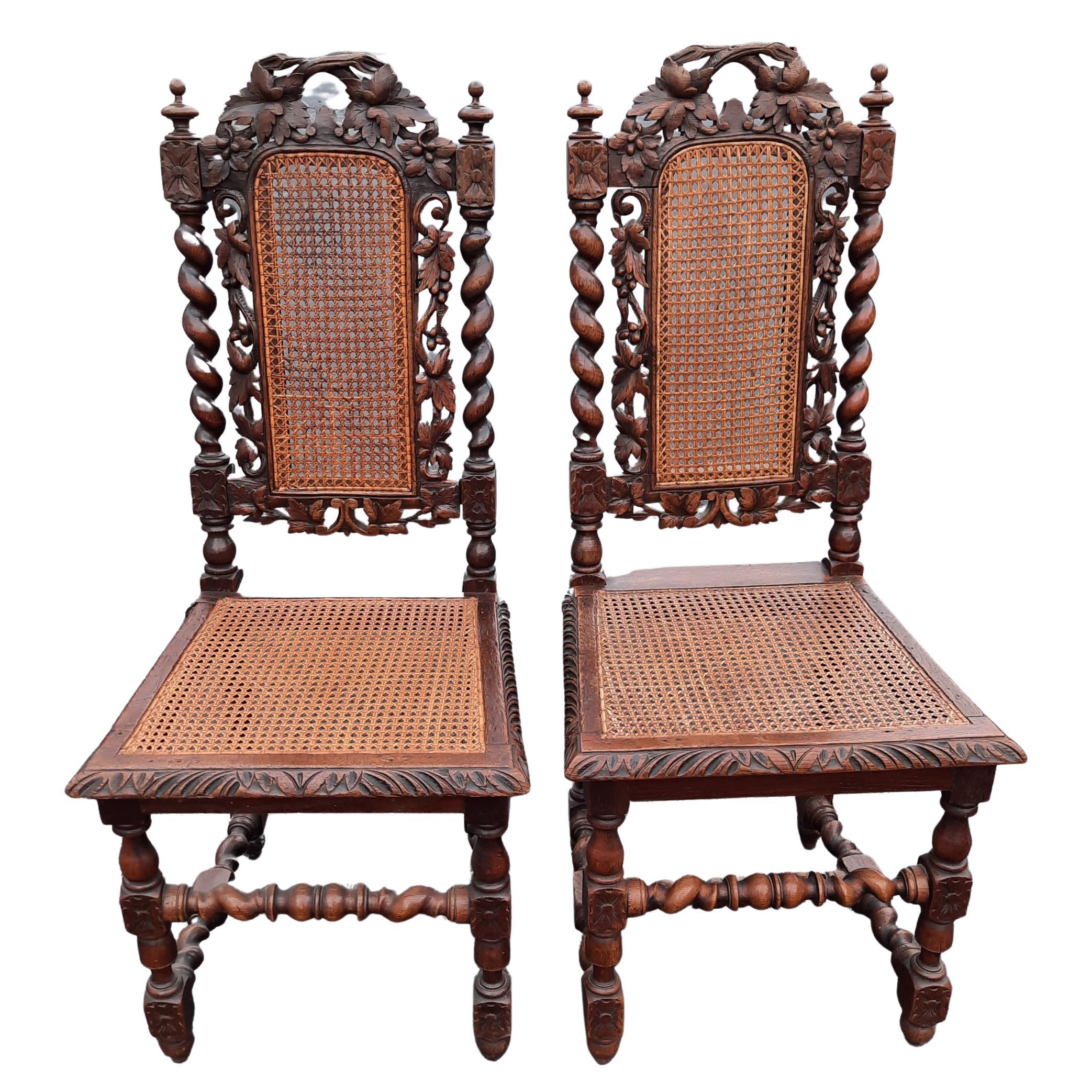 A very decorative set of 4 of antique Jacobean chairs in oak with custom loose cushions They have elaborately carved backs with carved and pierced central panels and a carved back rail depicting vine leaves. The side supports are barley twist and