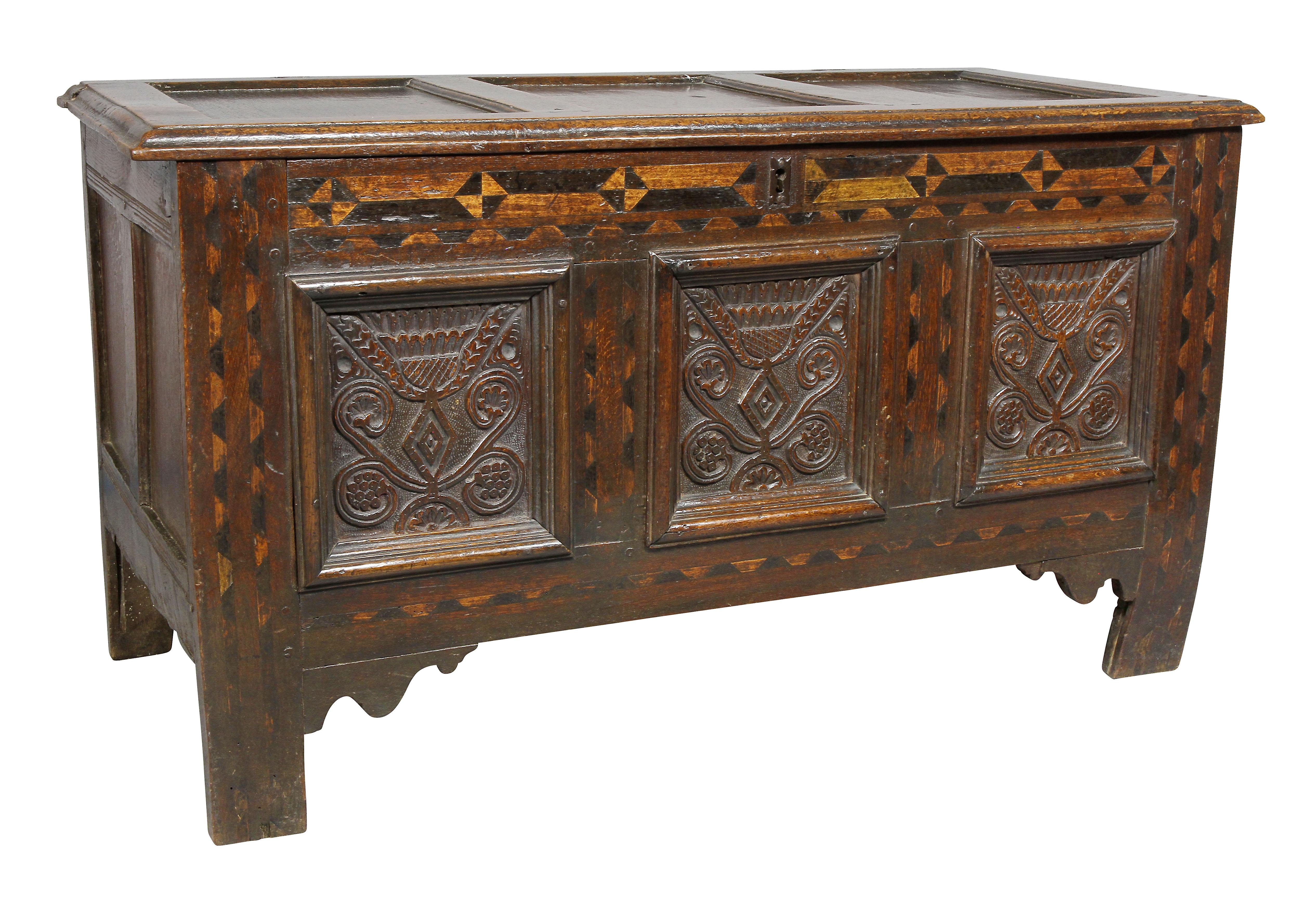 With panelled hinged lid over a case with geometric inlays and carved panels raised on square section legs.