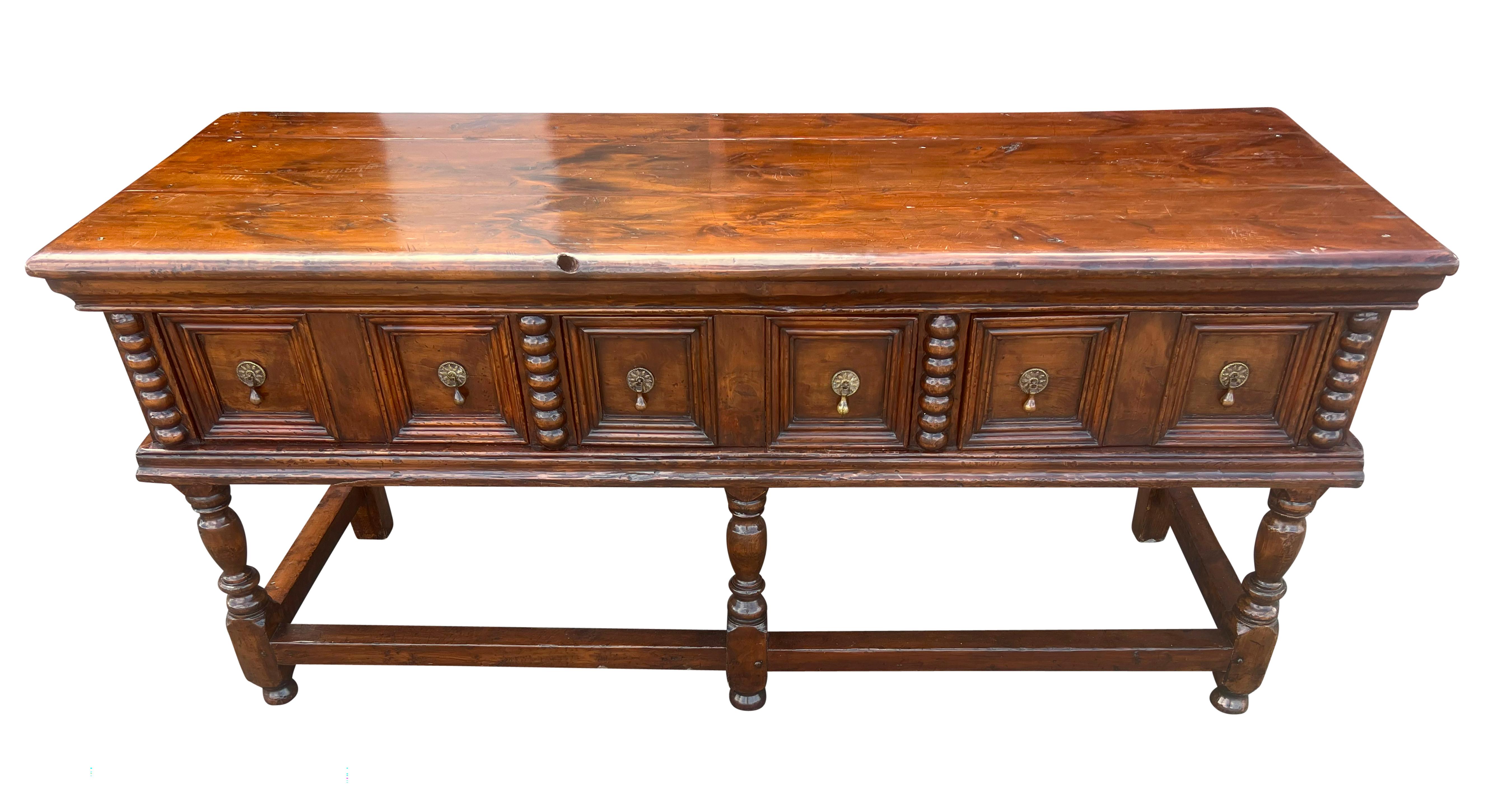 Rectangular top over three paneled drawers with brass tear drop handles, raised on turned legs with box stretchers. From the estate of Bartlett Burnap, Palm Beach, Florida.