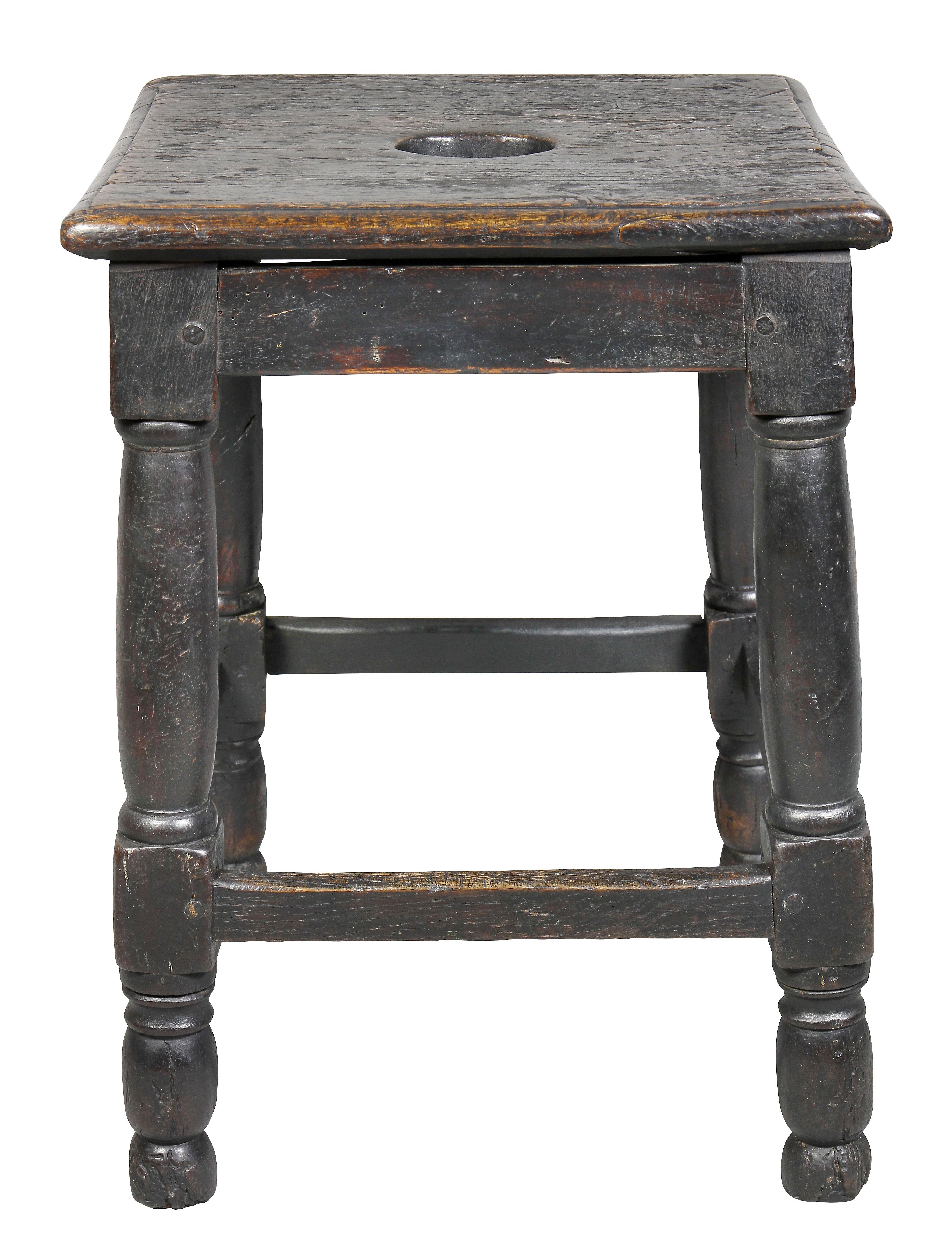 Almost square top with hand cutout over a simple frieze, raised on turned legs and joined by a box stretcher. W. Hodgins Estate.