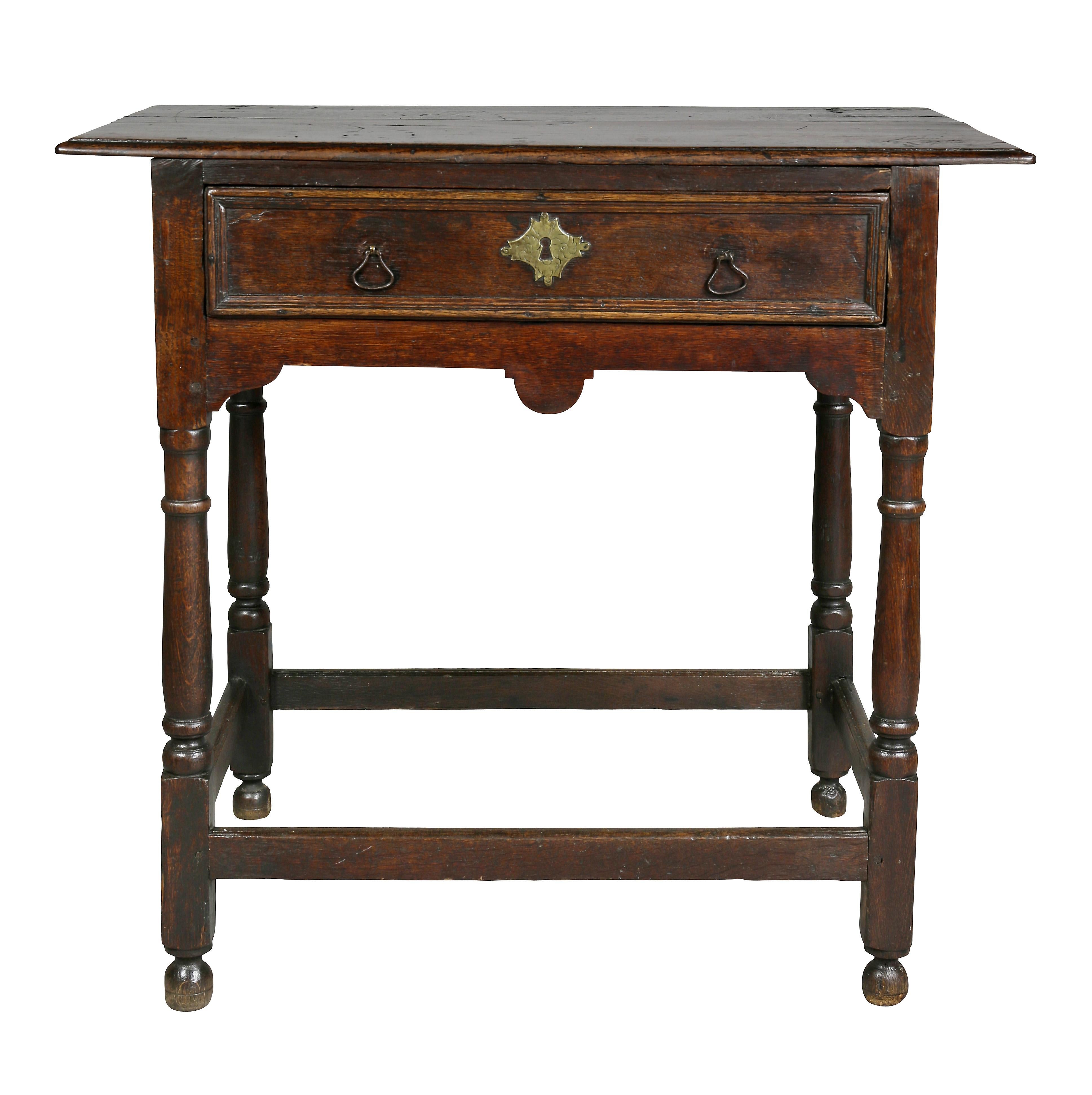 Rectangular top over a single drawer, raised on turned legs joined by a box stretcher, bun feet.