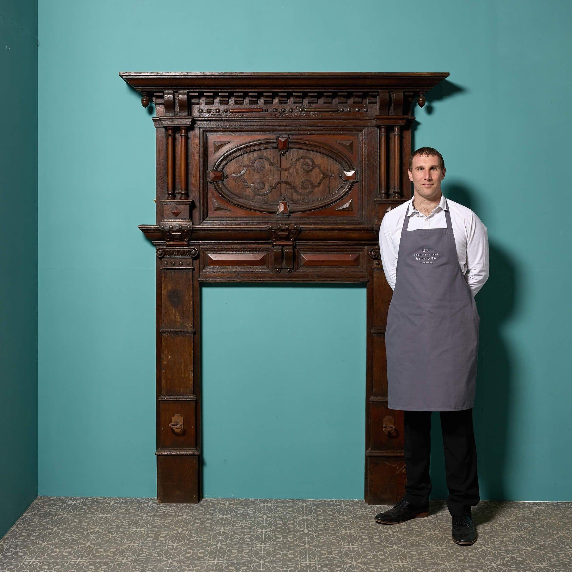 An English Jacobean period fire surround, salvaged from a property in Norfolk. Largely untouched, original condition. Of oak construction, with applied carved fruit-wood moldings.