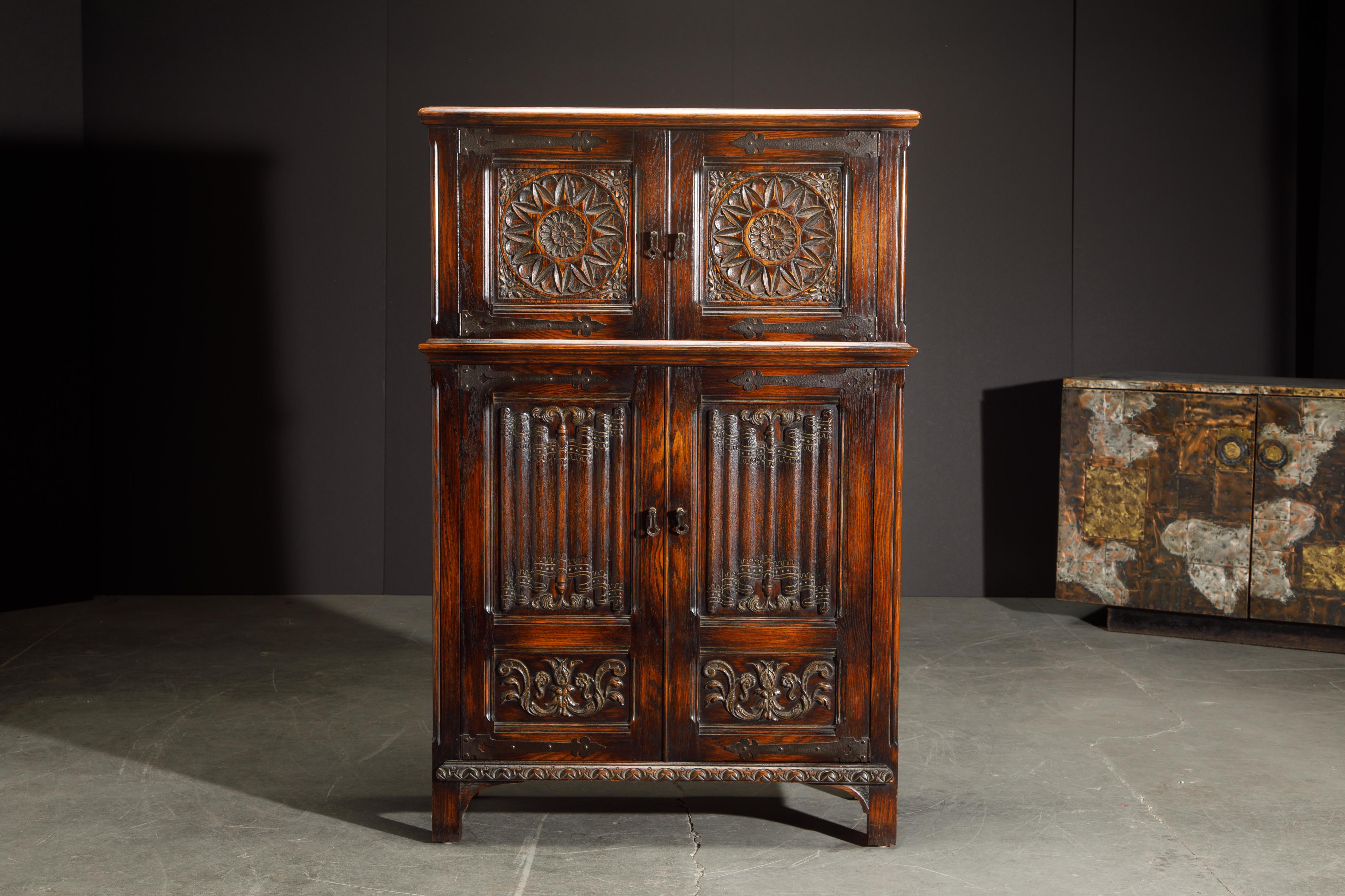This gorgeous carved oak highboy cabinet is in the Jacobean Revival style with intricate detailing and ample storage space. We also have in other listings the matching pieces from this set which include a sideboard credenza, lowboy server cabinet