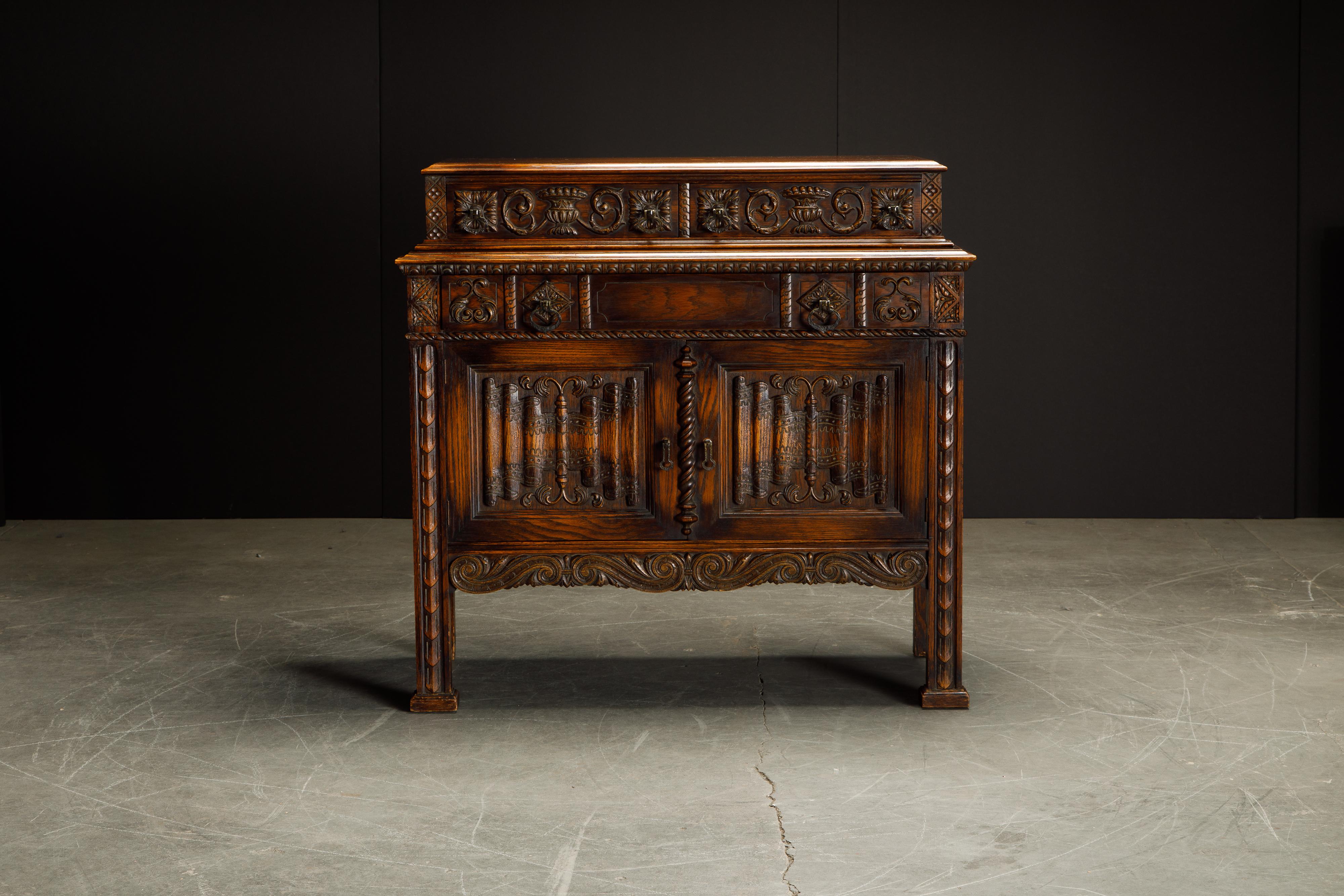 This gorgeous carved oak server cabinet is in the Jacobean Revival style with intricate detailing and ample storage space. We also have in other listings the matching pieces from this set which include a sideboard credenza, highboy cupboard cabinet