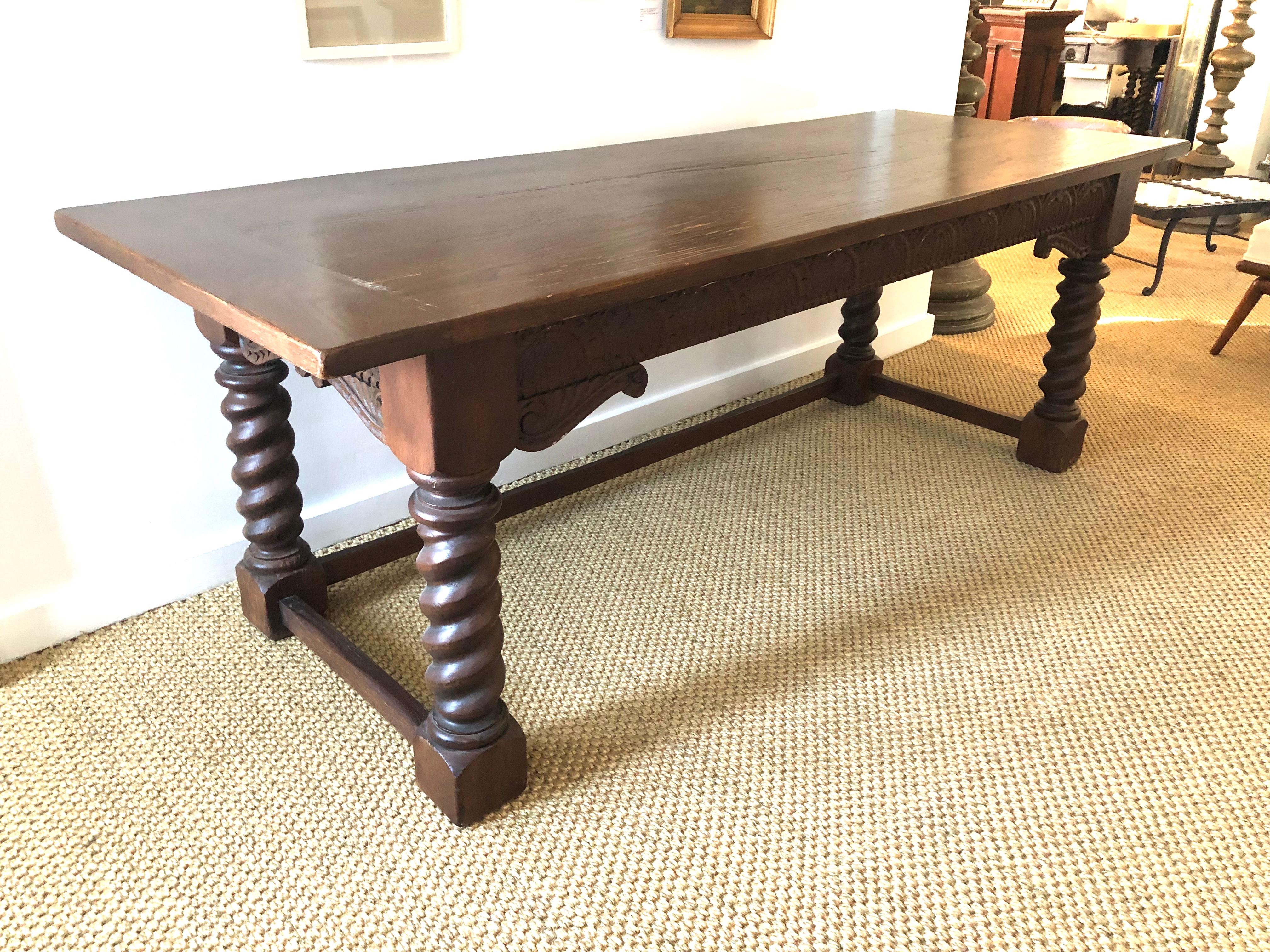 A Jacobean style carved solid oak refectory table the rectangular top with hand hewn edges and breadboard ends, over a frieze carved fan and scroll decorations raised on 4 barley twist legs joined by 3 hand hewn cross stretchers. One stretcher was