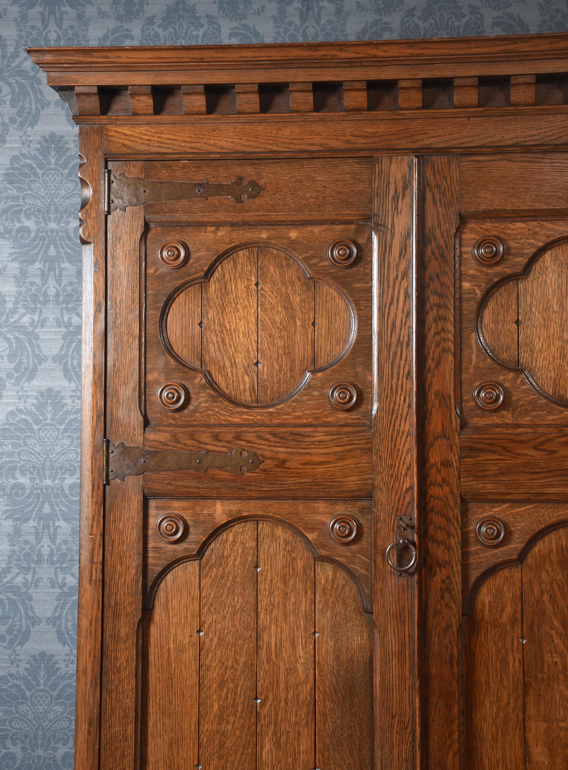 British Jacobean style carved oak three door wardrobe For Sale