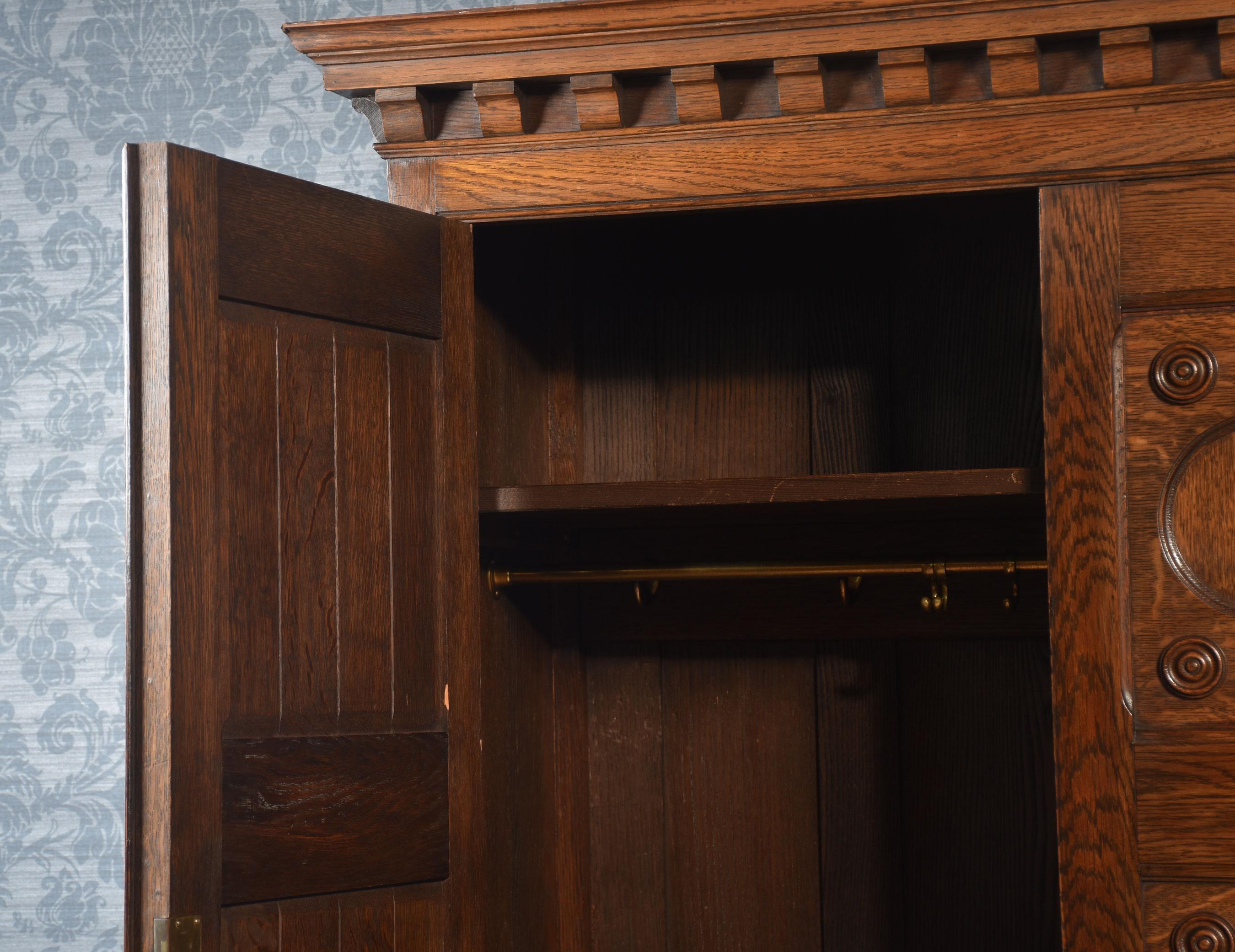 20th Century Jacobean style carved oak three door wardrobe For Sale