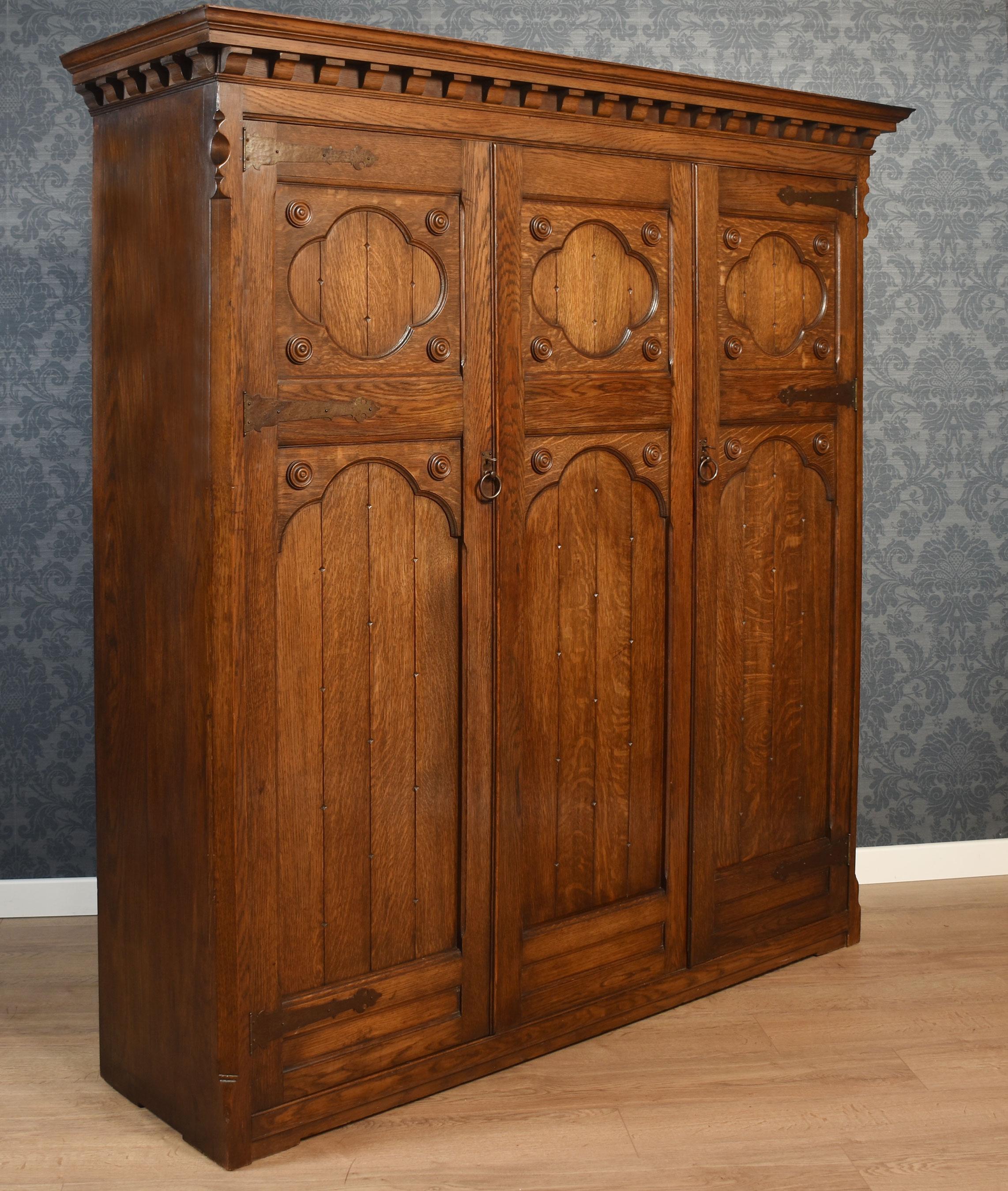 Oak Jacobean style carved oak three door wardrobe For Sale