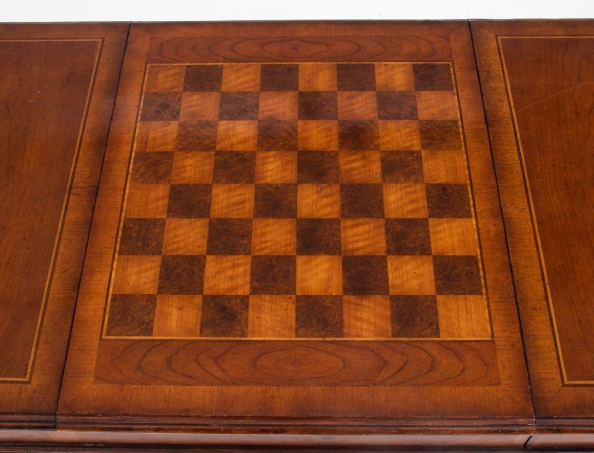 Jacobean style walnut coffee or games table by Lilian August, the rectangular surface inlaid with a chess/checkerboard inset into a side above a recessed backgammon board, the top above two short drawers and two false fronts with brass teardrop