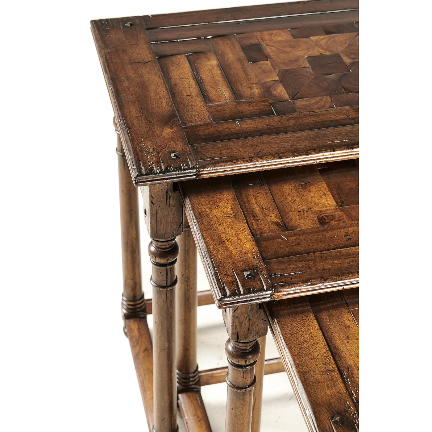 Cet ensemble exquis de trois tables gigognes témoigne d'un travail artisanal de qualité, avec des plateaux en bois d'huître incrusté et une finition en noyer antique richement vieillie. 

Fabriquées à la main en bois d'acacia de première qualité,