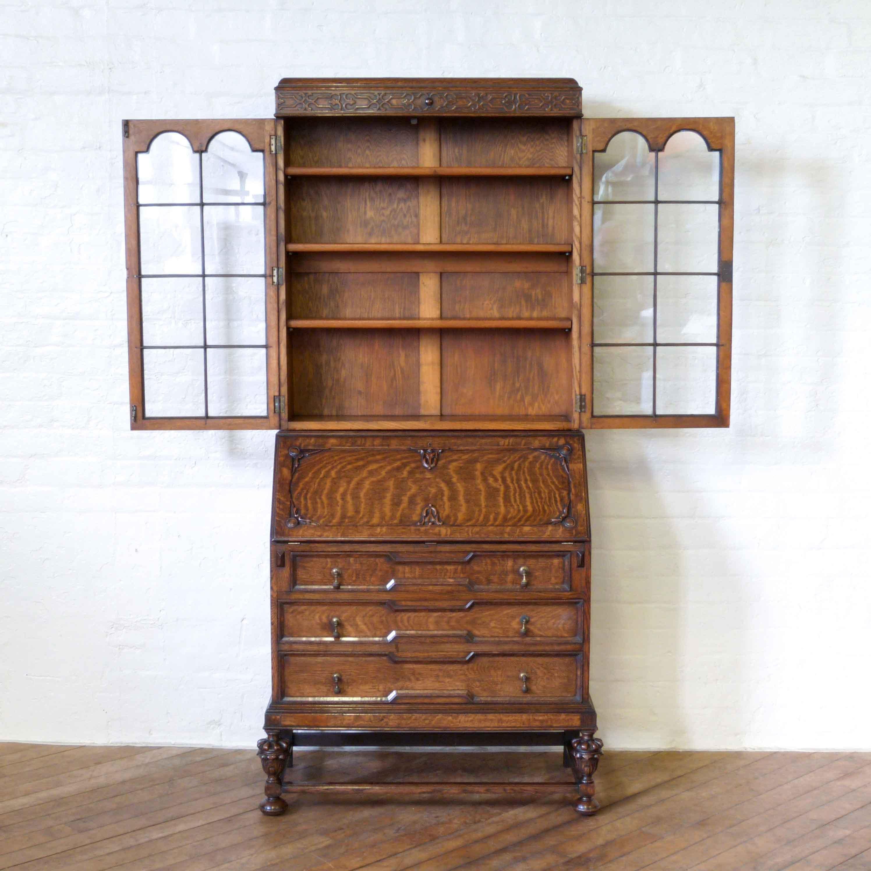 A beautiful quality solid oak bureau bookcase with a marvellous cantilever interior. The geometric mouldings to the drawers are typical of a mid-17th century Jacobean design, as are the carved baluster legs. The astragal glazed bookcase top splits