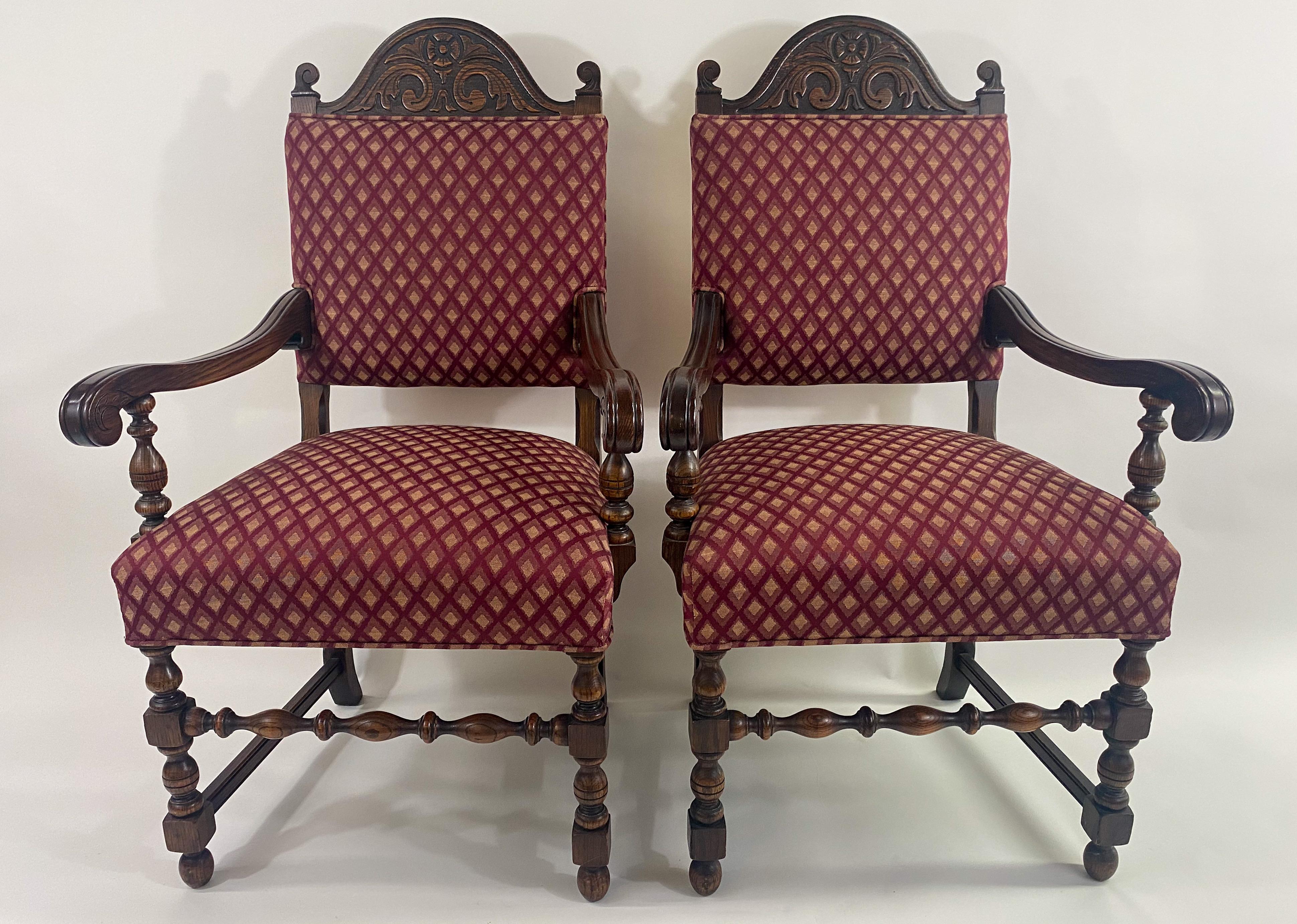 A pair of classic Jacobean style arm or Berger chairs. The chairs are hand-carved of high quality oak and show elegant geometrical motifs. The chairs feature serpentine crest rail and turned baluster legs connected with an H stretcher. The beautiful
