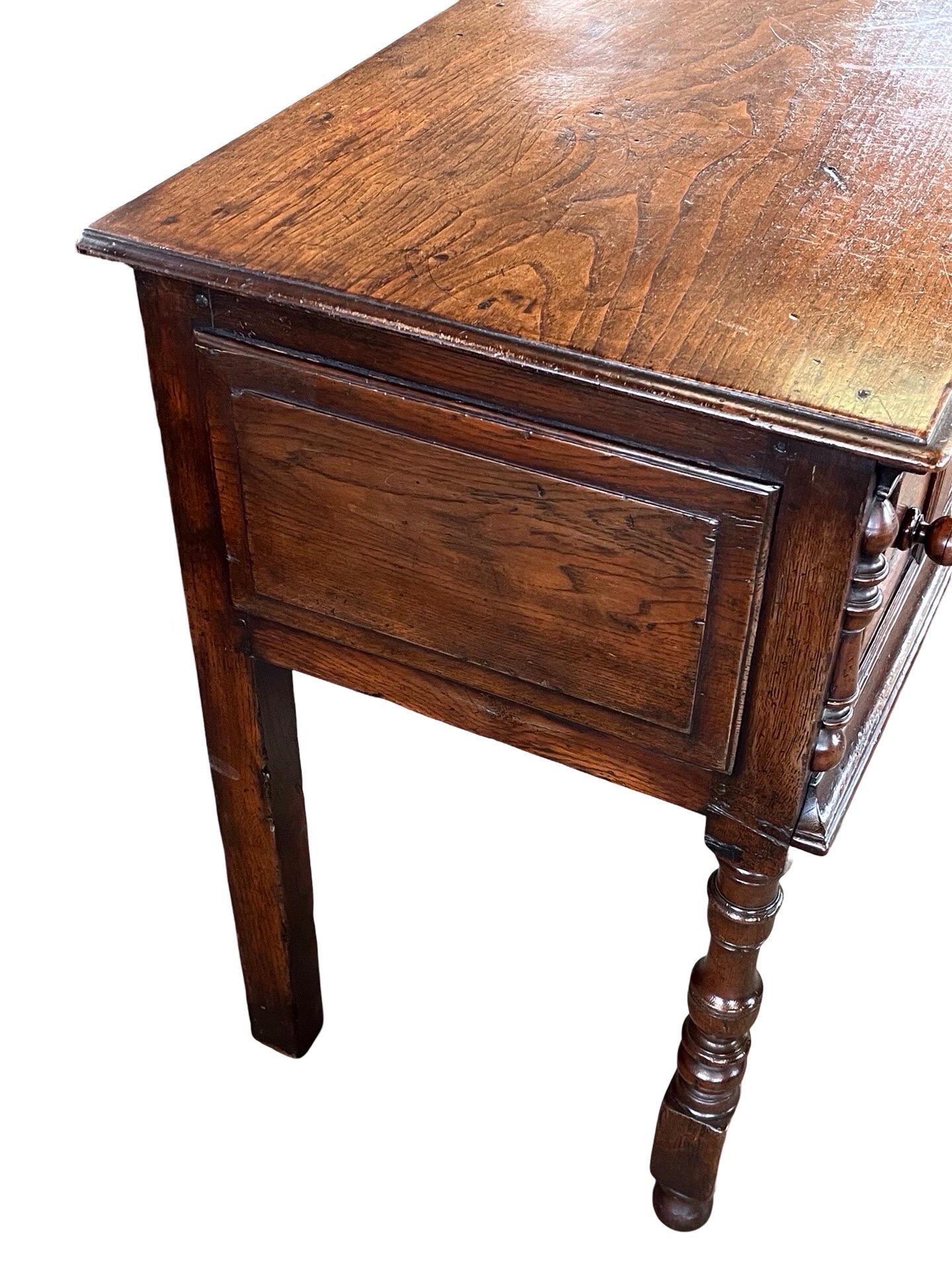 Console table / dresser base hand-made in England in the early 1800s using oak. The piece is very elegant in proportions and color, has is decorated throughout by simple molding placed strategically to give it depth. The console table features three