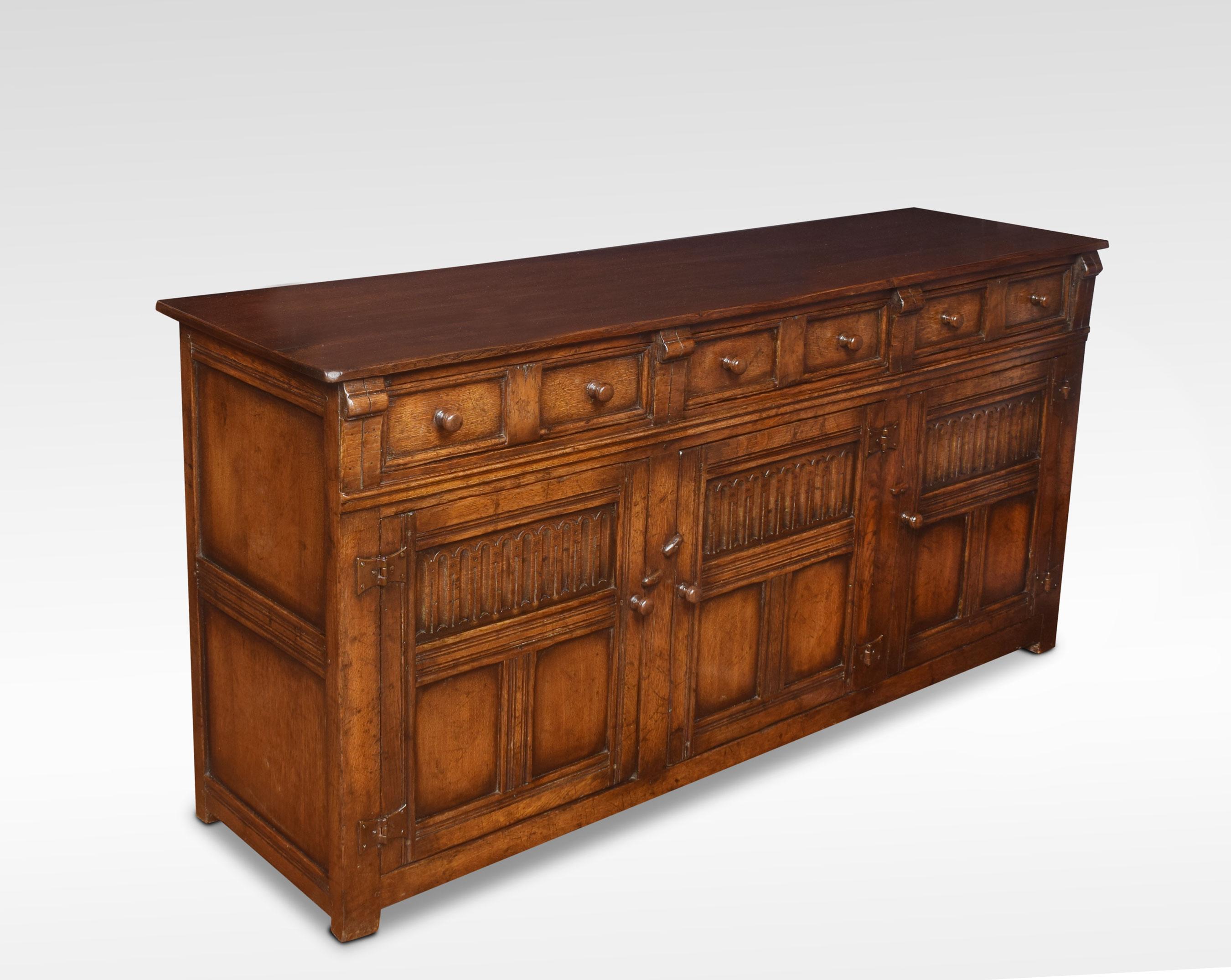 Jacobean style oak dresser base, the large rectangular top to the frieze fitted with three drawers above three paneled and fluted doors opening to reveal a large storage area. All raised up on stylized feet.
Dimensions:
Height 31.5 inches
Width