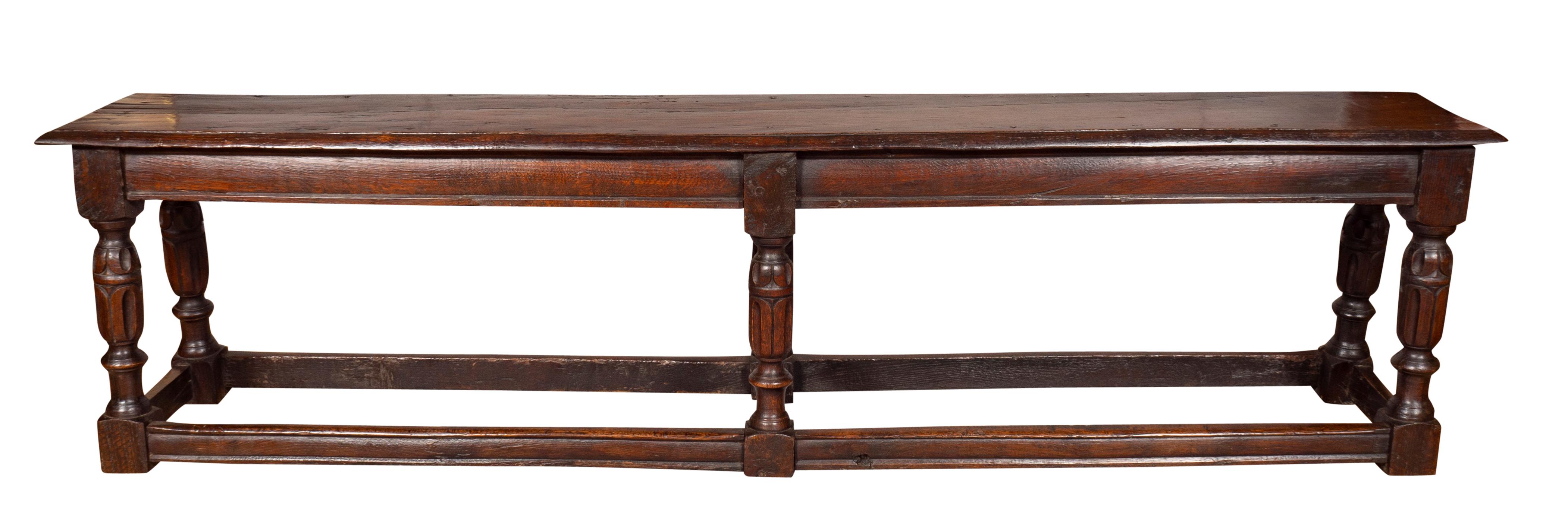 Long rectangular plank top and molded frieze and turned carved legs and box stretchers.