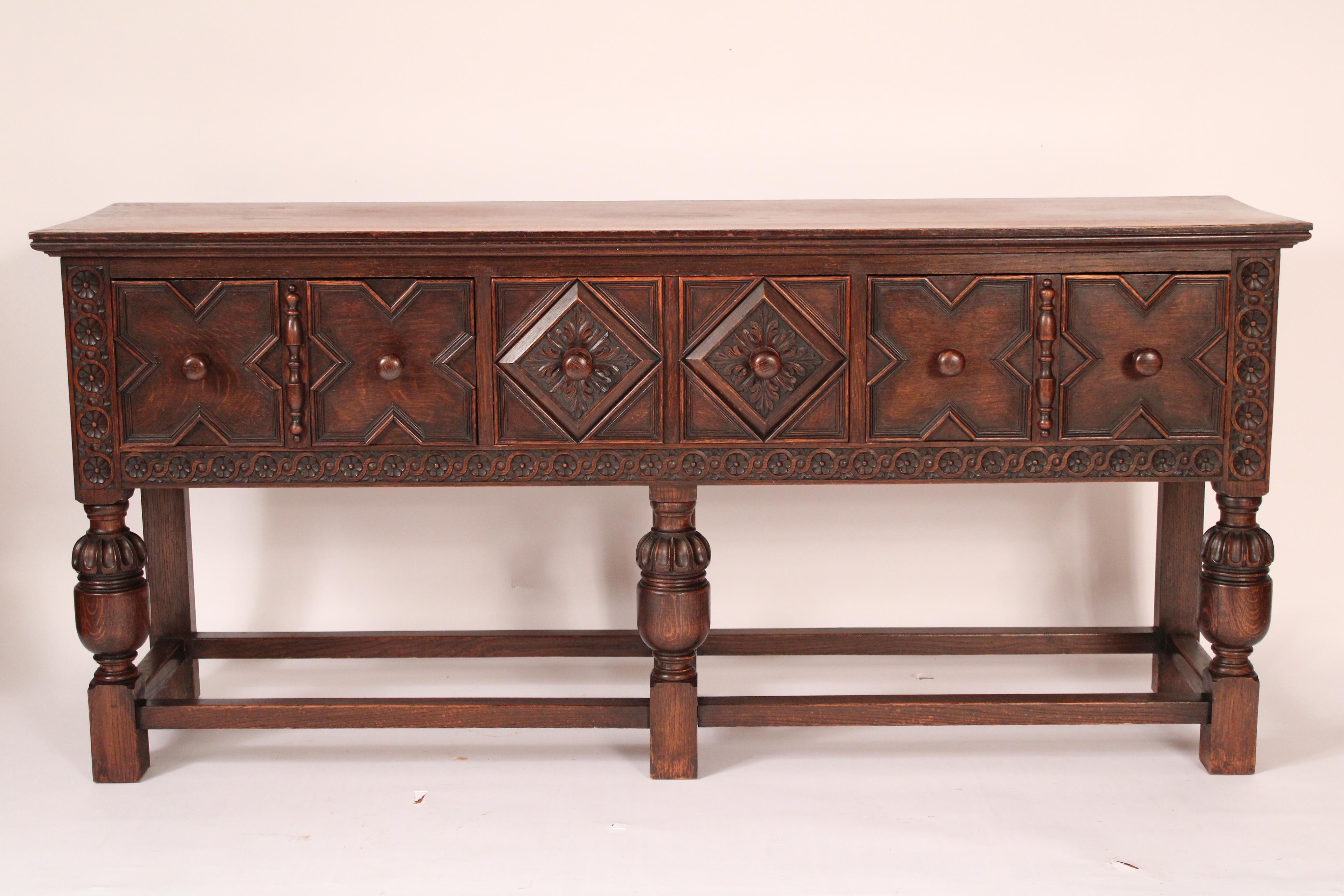 Buffet en chêne de style jacobéen, vers 1920. Avec un plateau rectangulaire, 3 tiroirs en frise, le tiroir central avec une moulure en forme de diamant insérée dans une sculpture florale, les deux tiroirs extérieurs avec des façades de tiroirs