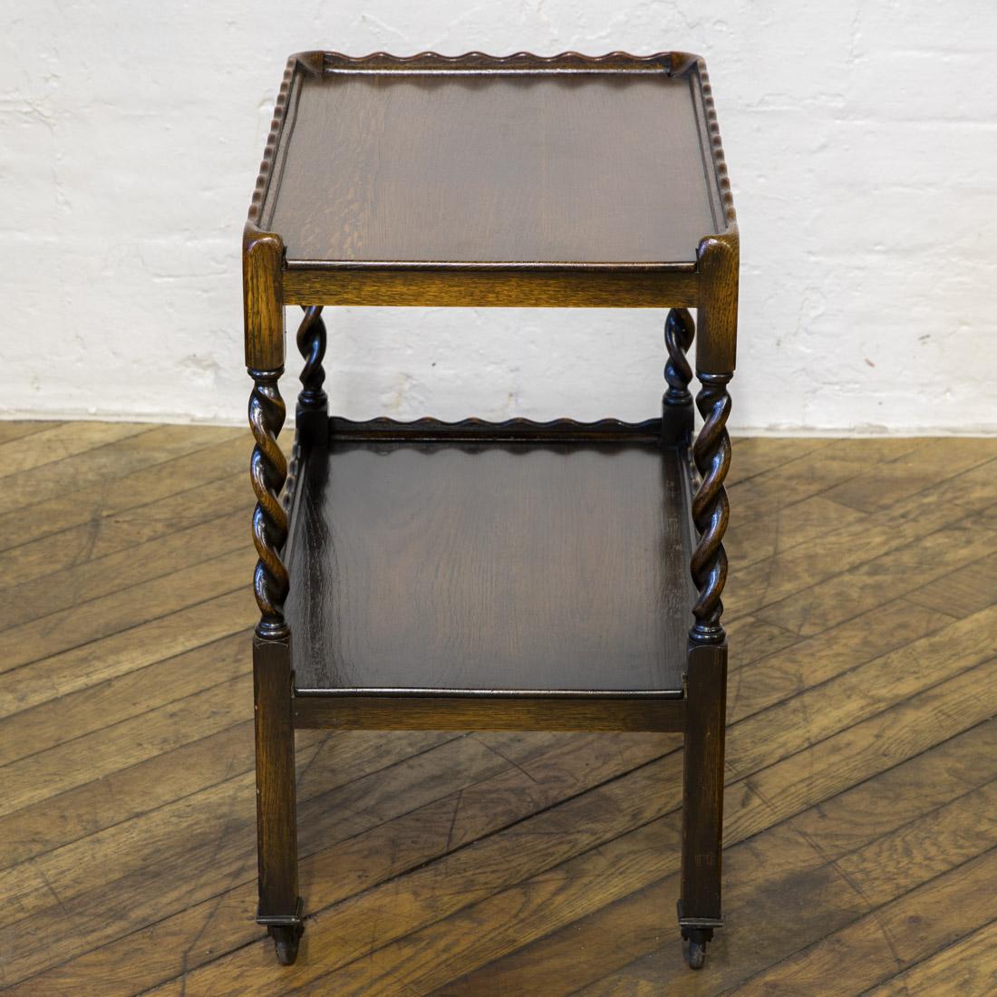 A lovely solid oak tea trolley with wonderful pie crust edges to its top and lower tier. Complimented with its barley twist legs and sat on its original castors. In excellent condition and ready to use and enjoy.
  