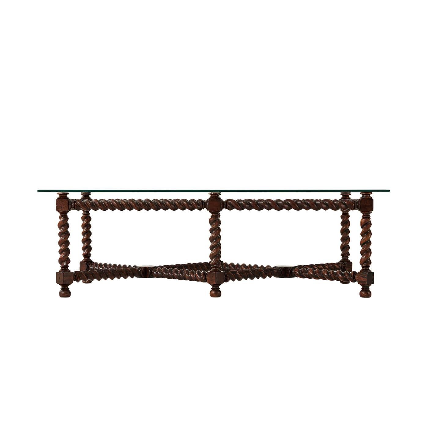 A rustic Jacobean-style spiral leg coffee table with a glass top. This rectangular coffee table has six oak barley twist carved legs with an 