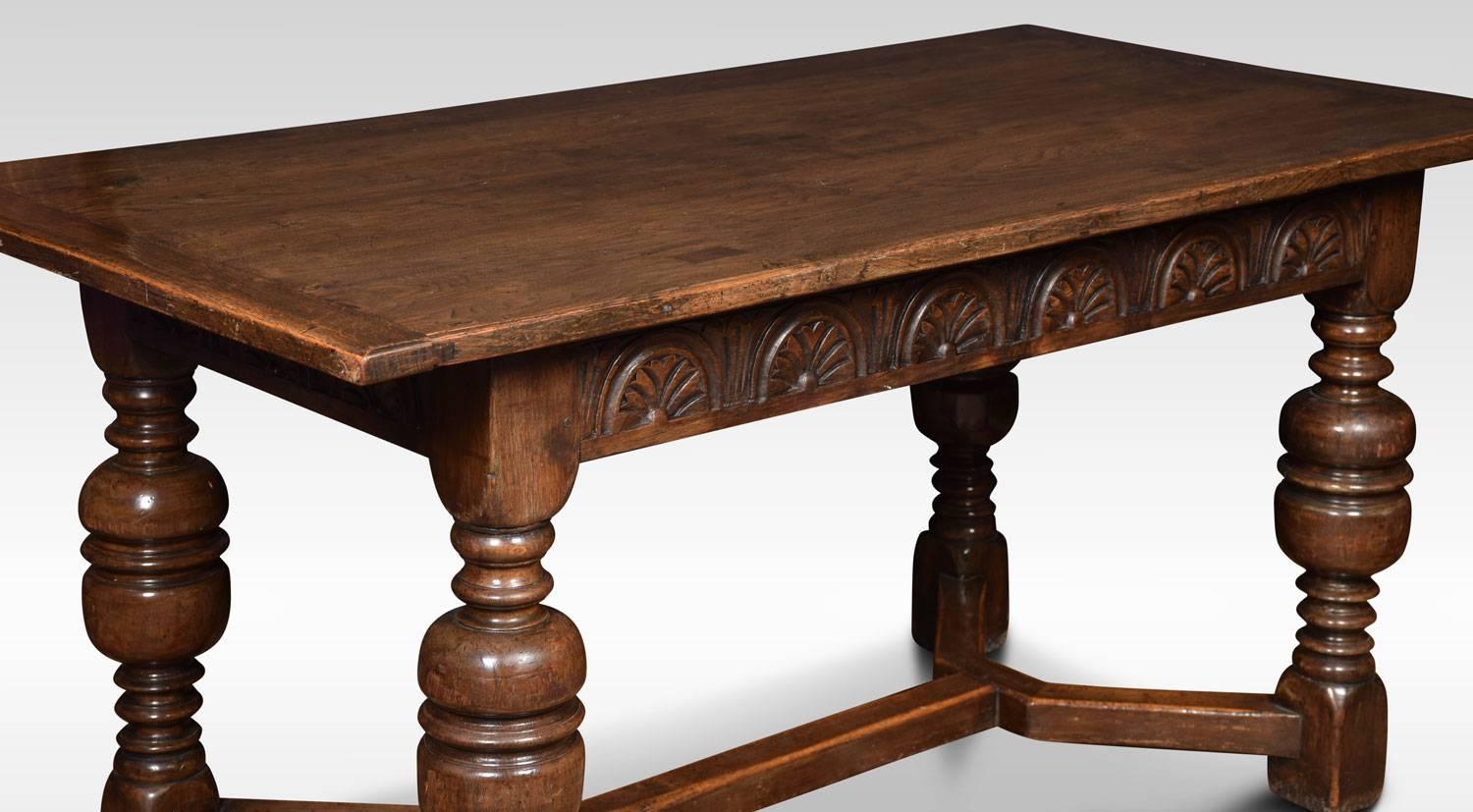 Oak refectory dining table the architectural rectangular plank top, above carved freeze and four turned supports leading down to block feet united stretchers. (Will seat 6-8 People) The top separates from the base for easy