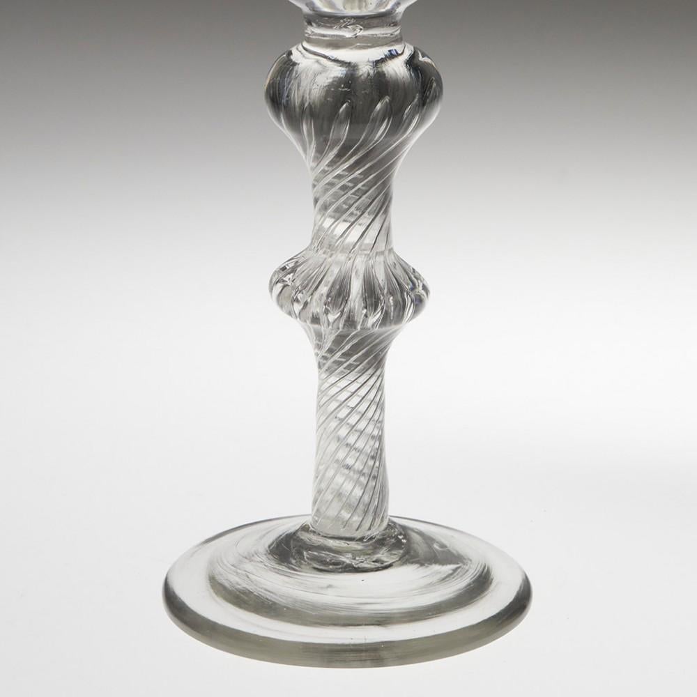 Heading : Jacobite engraved air twist wine glass
Period : George II
Origin : England
Colour : Clear, good grey tone
Bowl : Round funnel, engraved with Jacobite rose and one rosebud.
Stem : Multi spiral air twist, large ball knop over medial angular