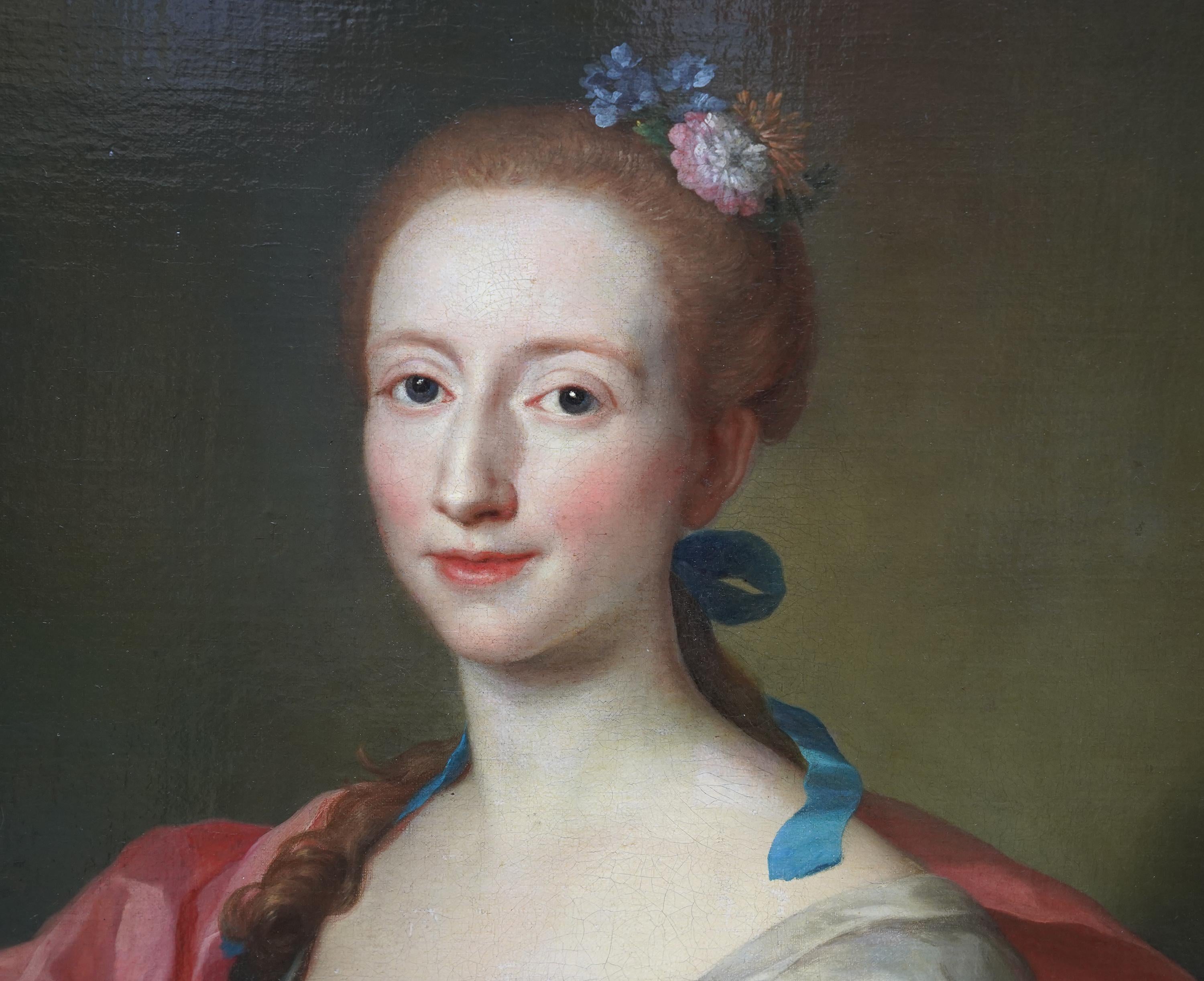 Este suntuoso retrato al óleo del barroco italiano se atribuye al círculo de Jacopo Amigoni. Pintado hacia 1720, es un retrato de medio cuerpo de una bella dama con vestido de seda blanca con lazos azules y manto rosa. Lleva el pelo castaño